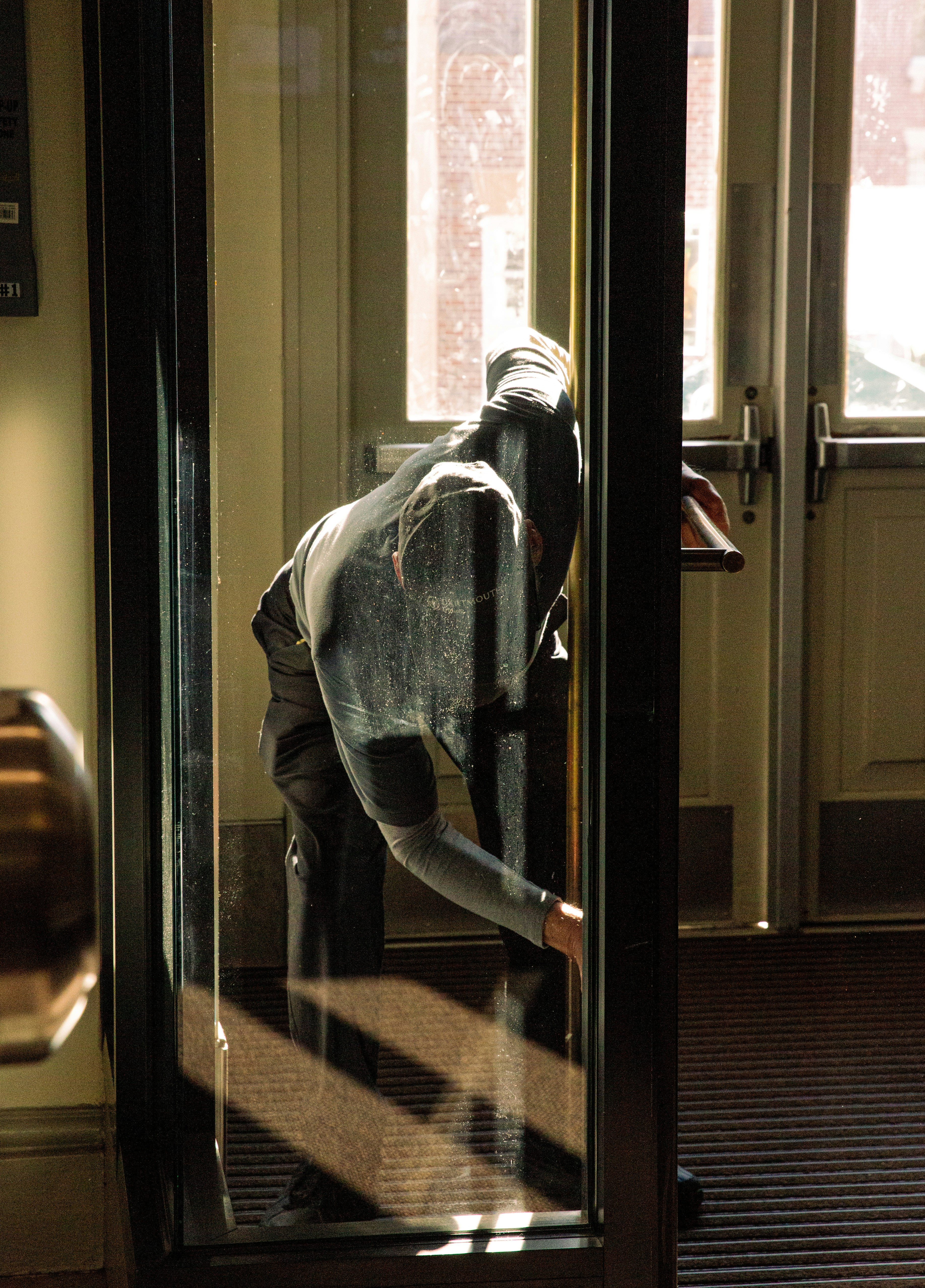 A person looks out a glass door.