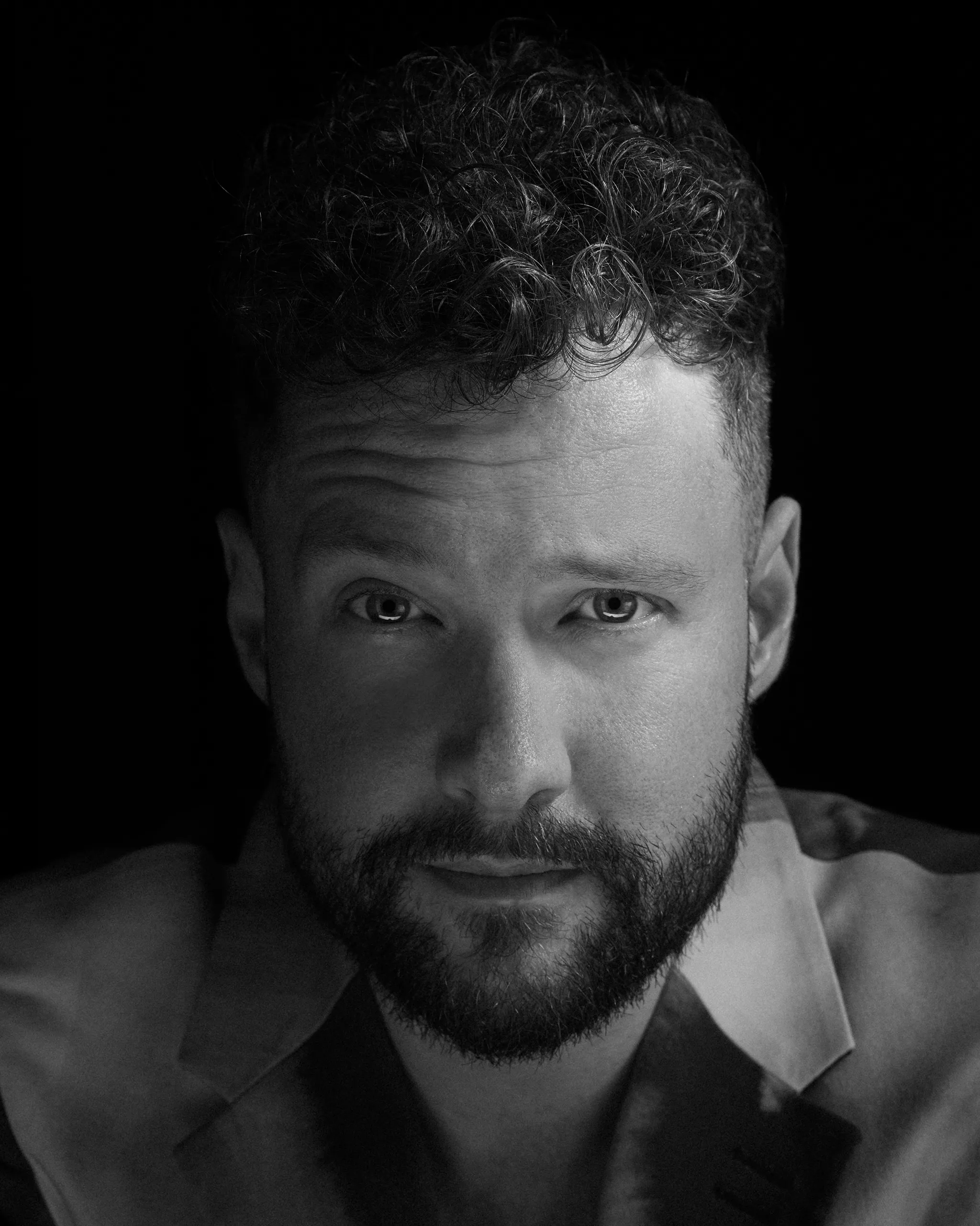 A sharp black and white studio portrait of singer Calum Scott.