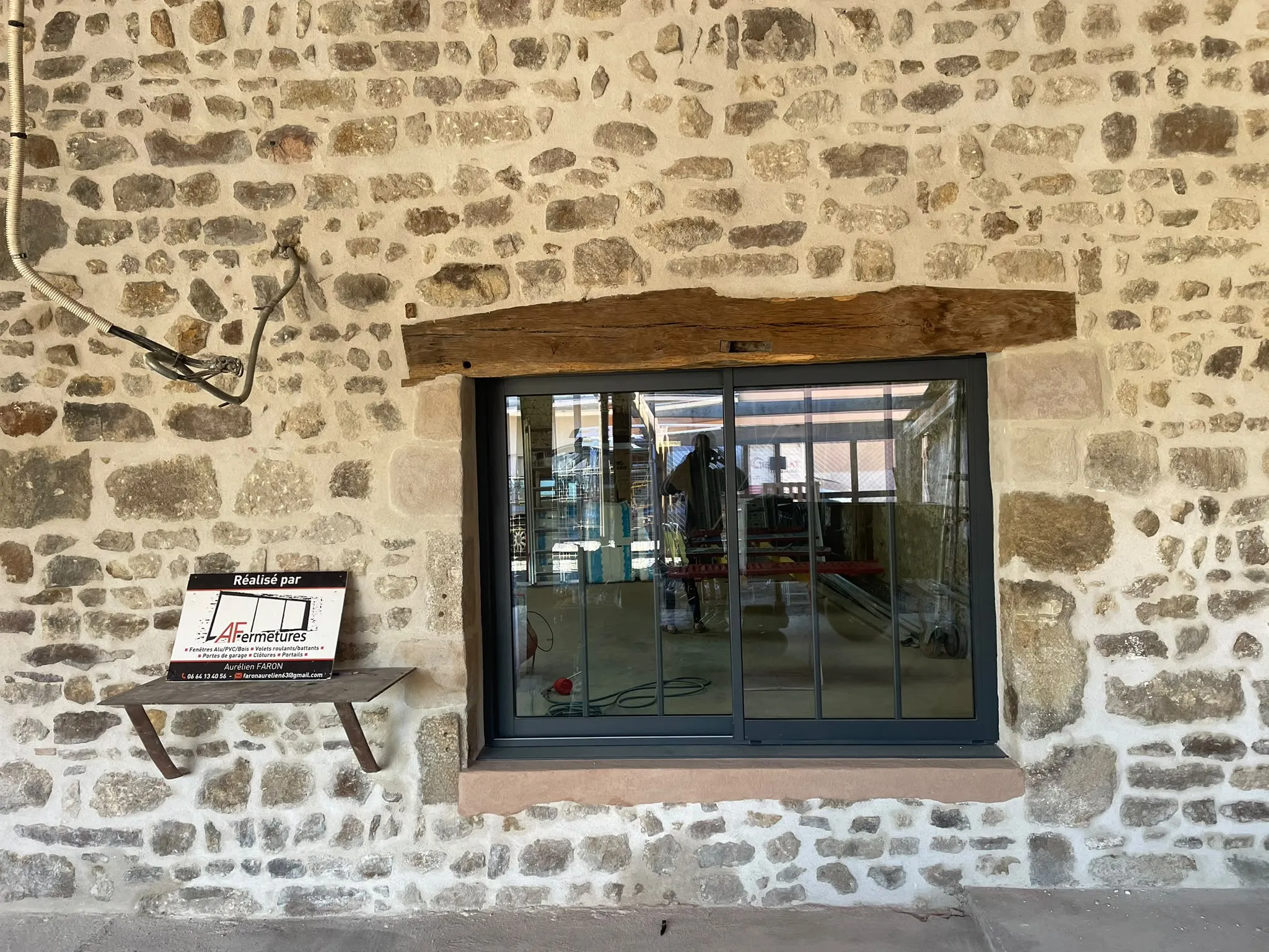 Fenêtre sombre dans une façade en pierre — AFermetures