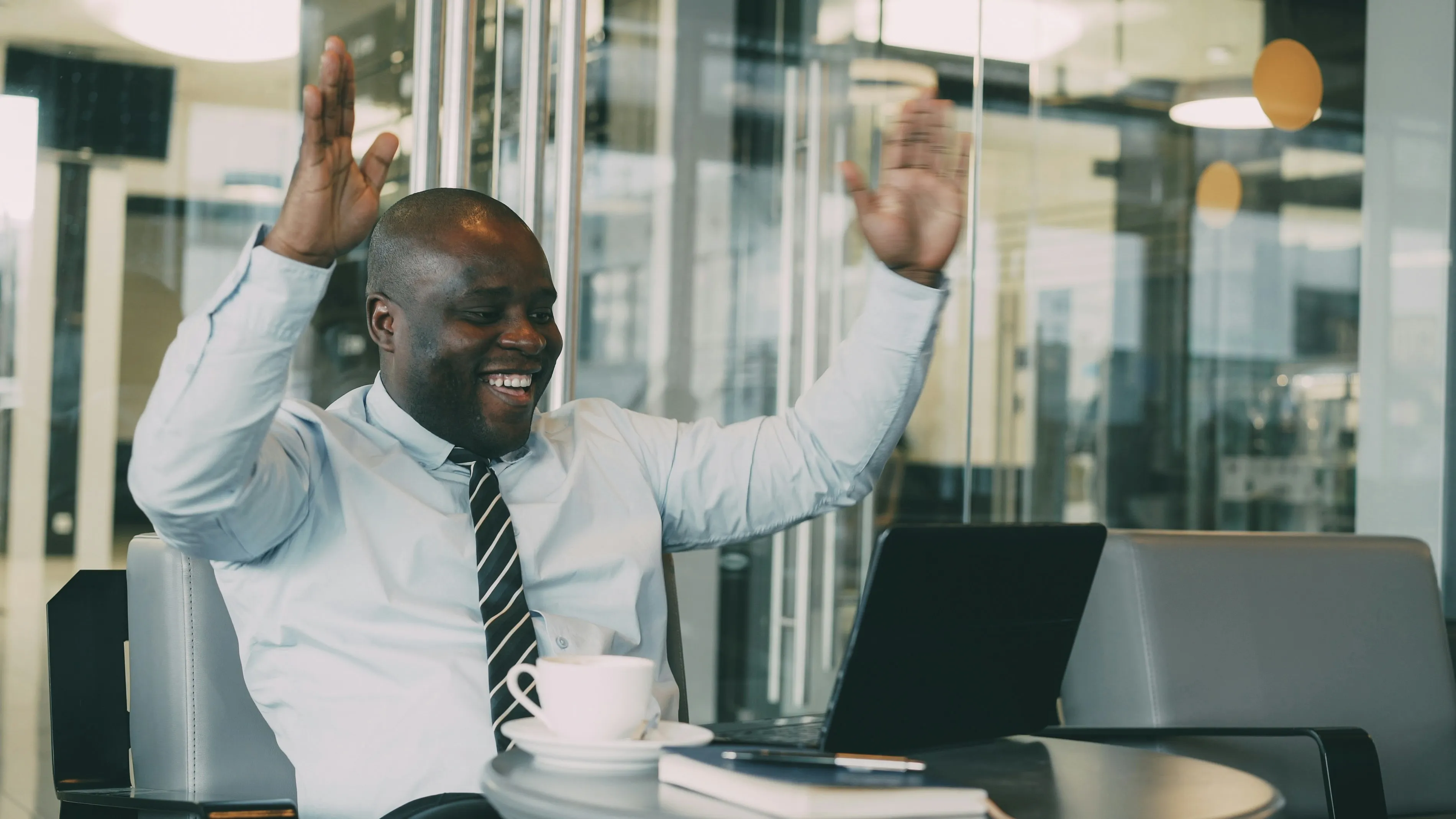 Man in office celebrating success with laptop