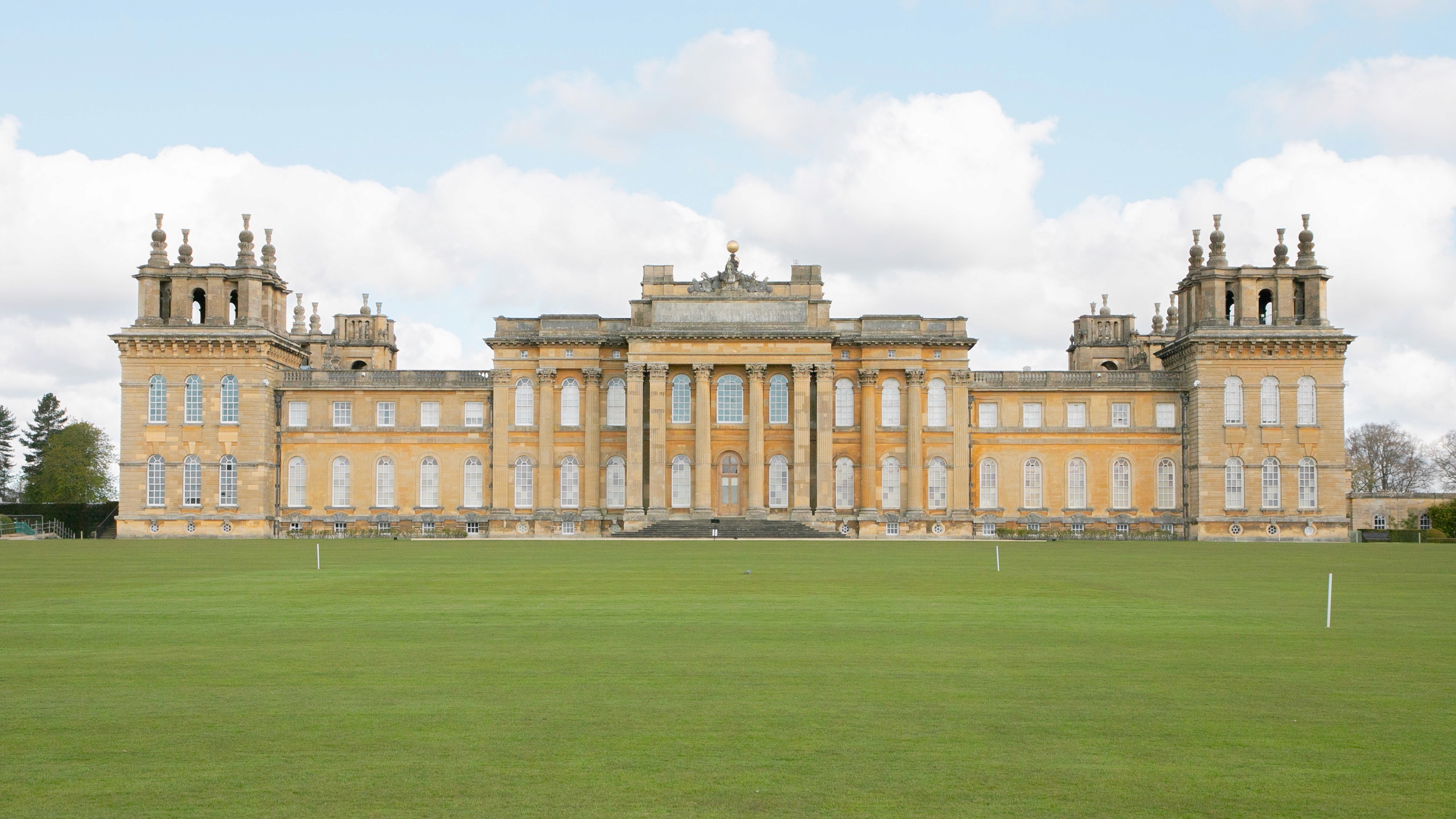 Two classic volkswagen beetles, one green, one cream.