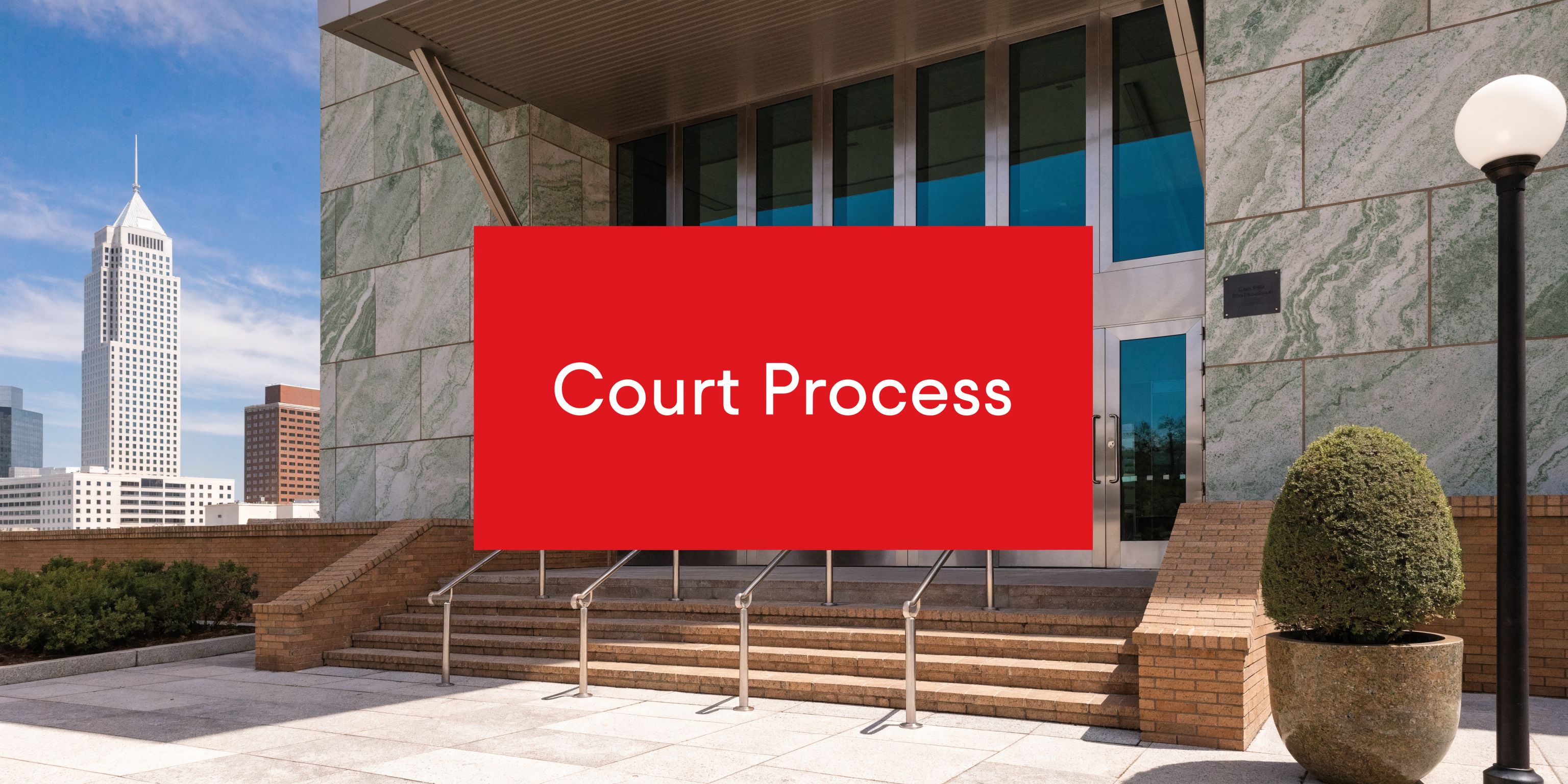 A modern building entrance with a red sign that says Court Process in white text.