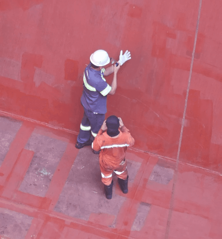 CARGOWARD marine surveyor performing a cargo hold cleanliness inspection in Brazil, using a white glove test and documenting hold condition for loading readiness.