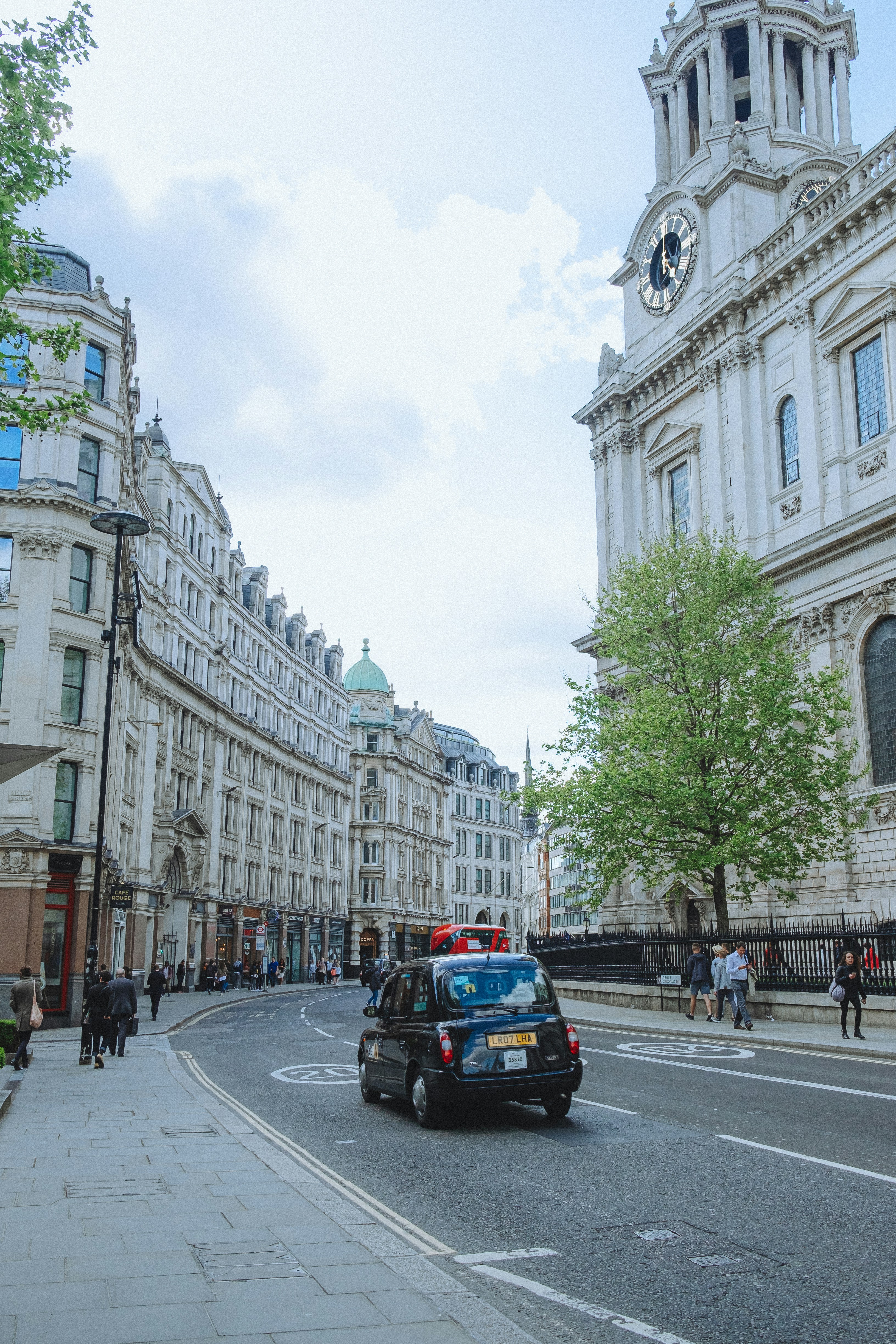 taxi car between brown buildings during day time