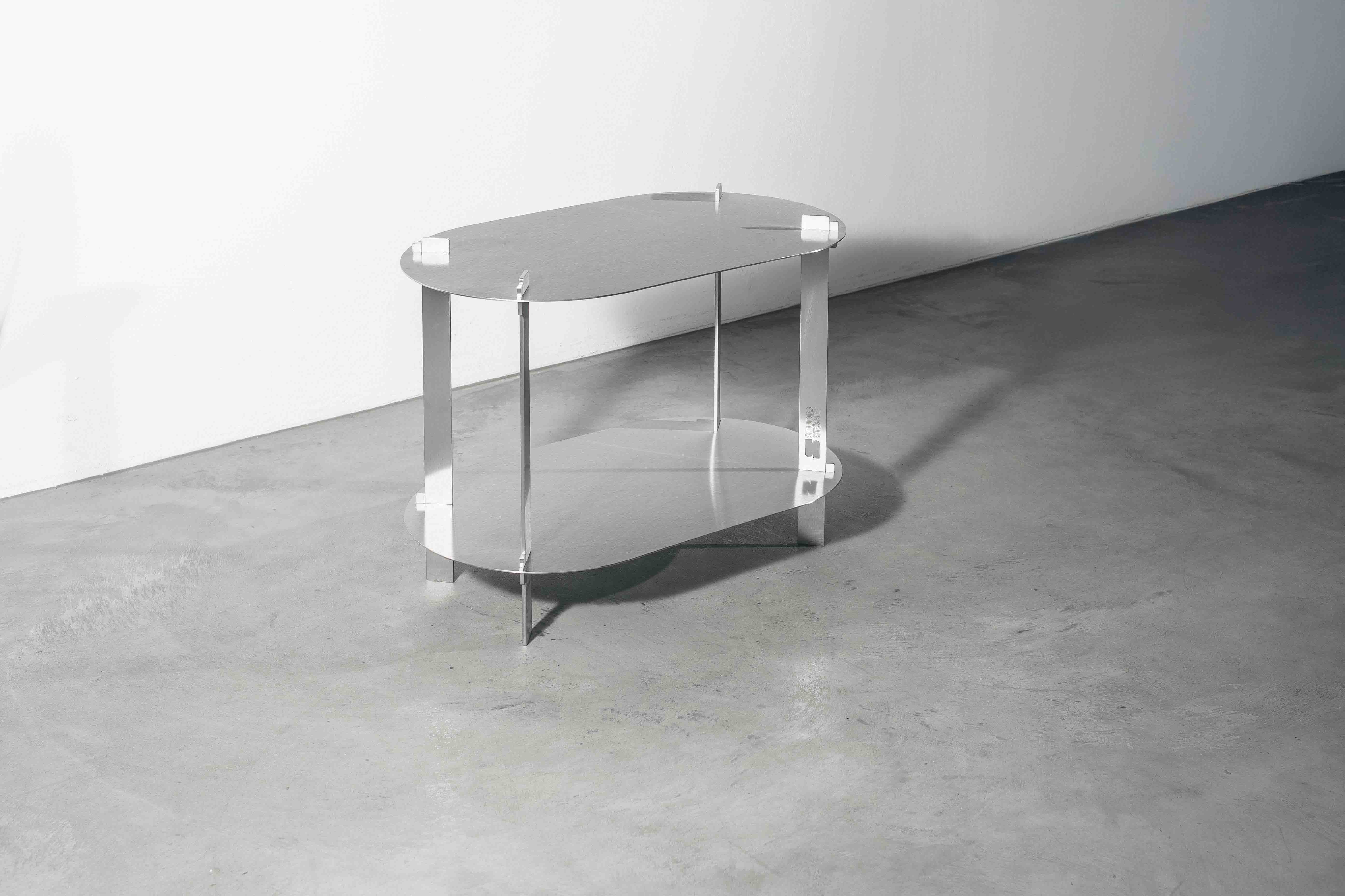 side view a metal designer table on a concrete floor