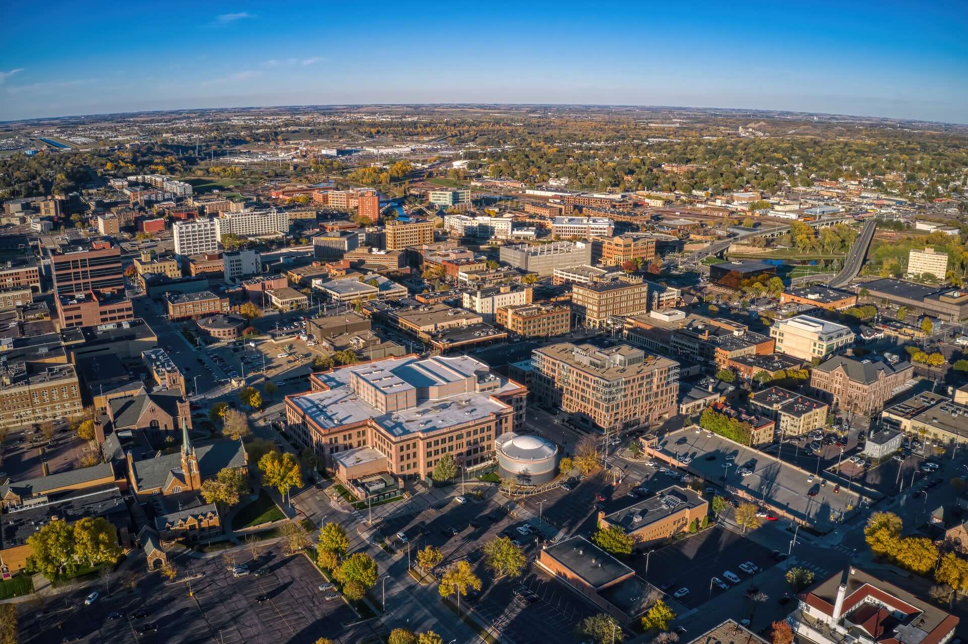Curving path through grassy area towards a modern bridge.