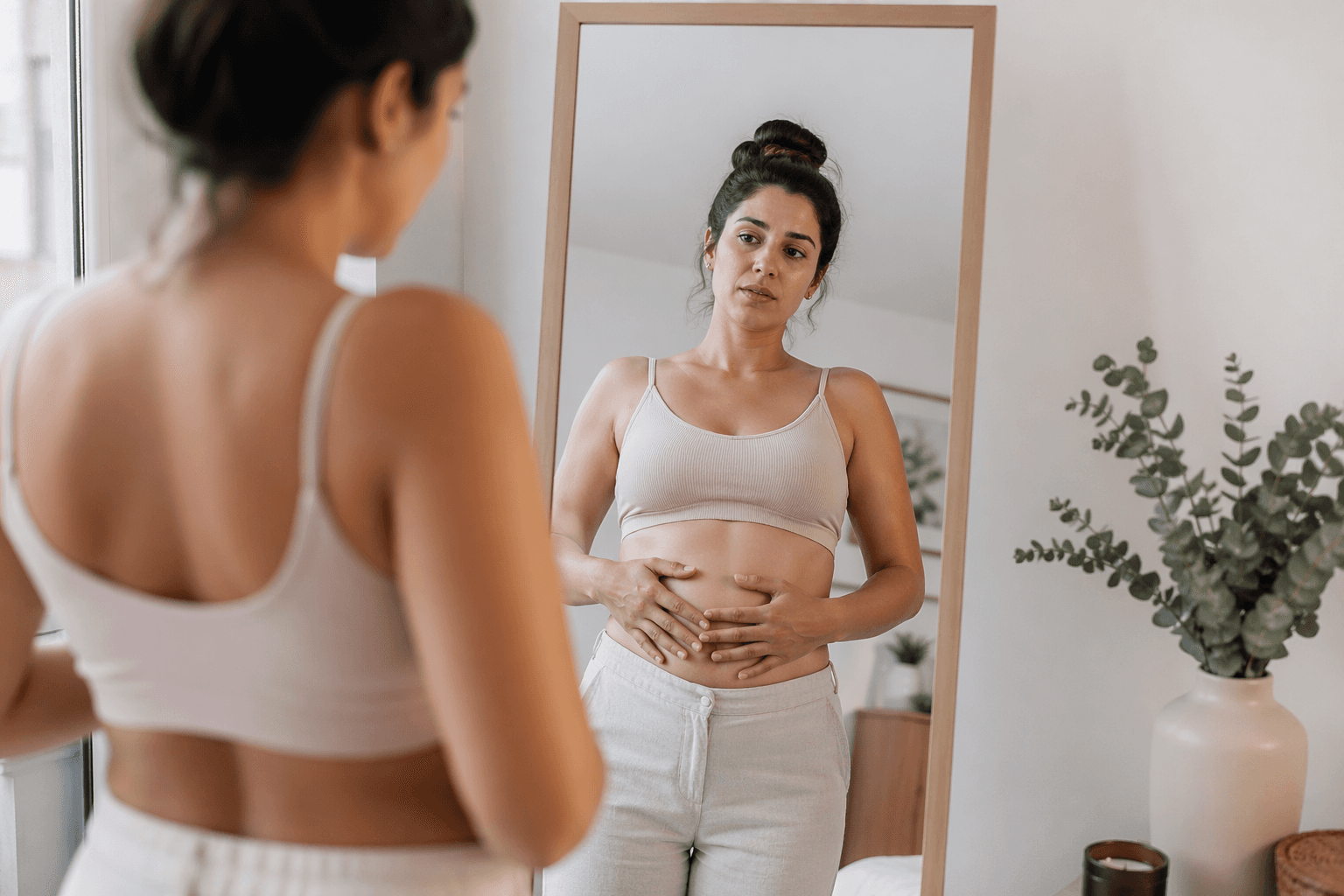 mujer mirándose al espejo con expresión de duda antes de una sesión de fotos en estudio