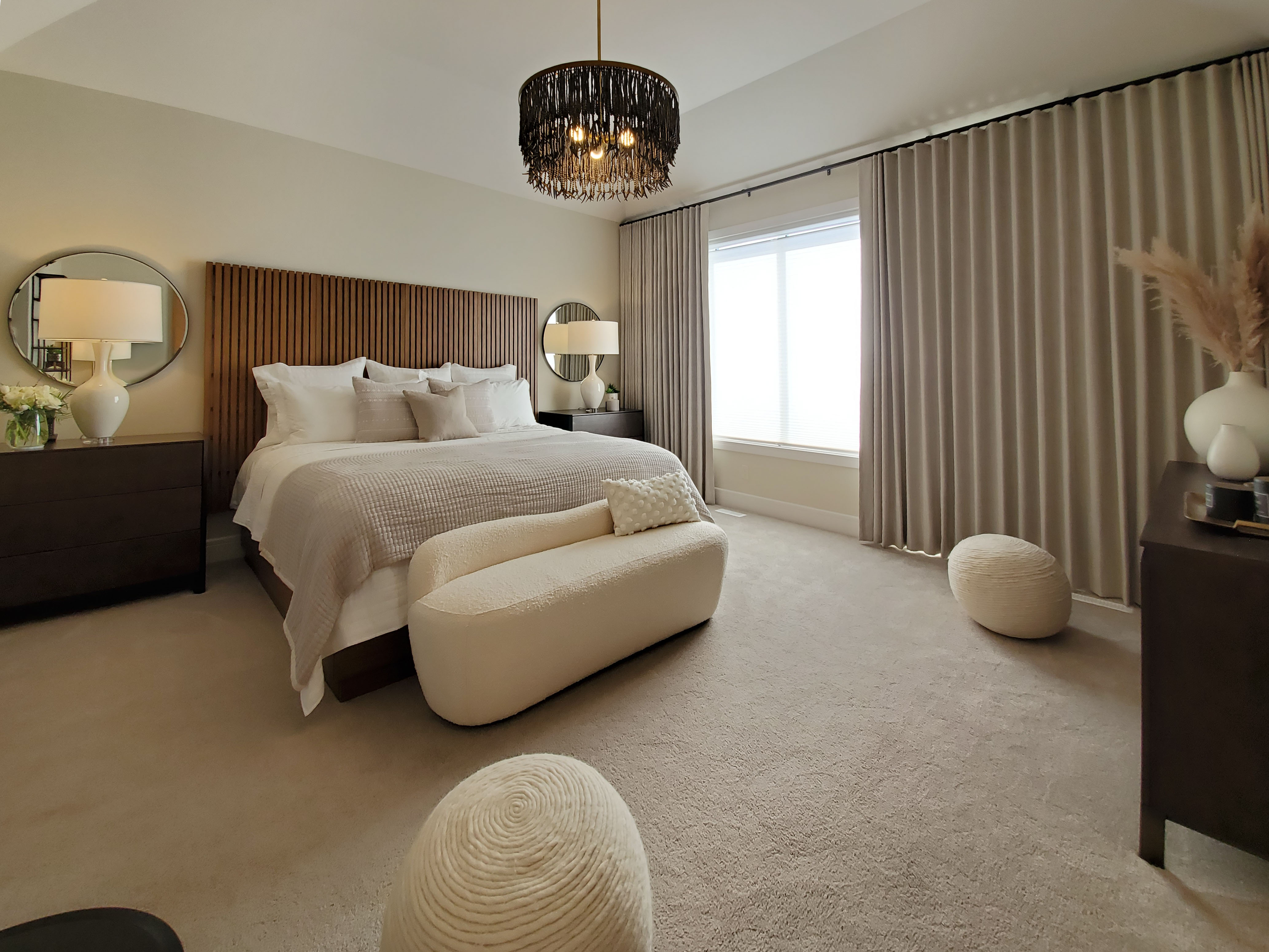 Image of Luxurious primary suite with beige furniture, wooden accents, and elegant window coverings by KHD Homes.