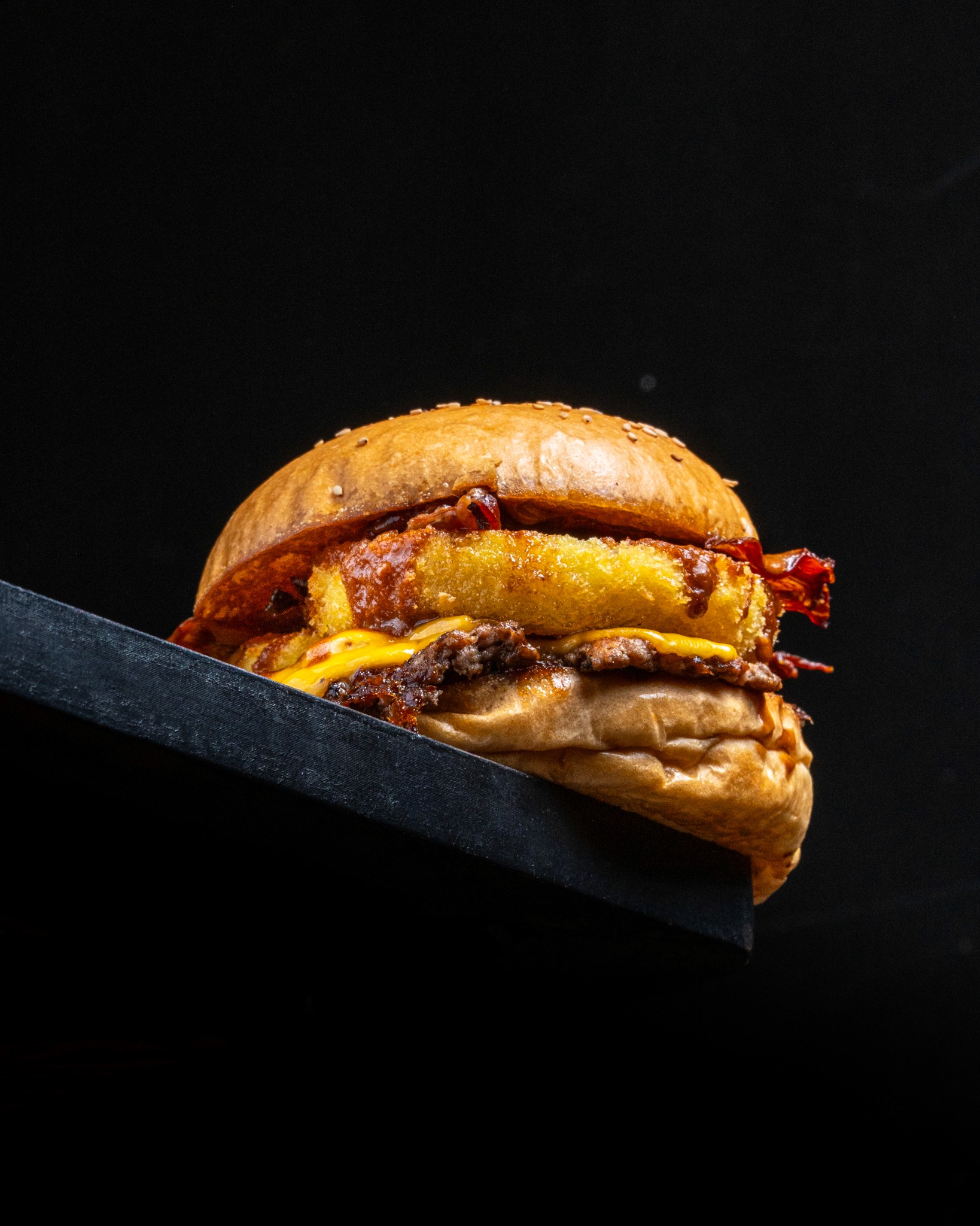Gourmet burger photographed against a dark background.