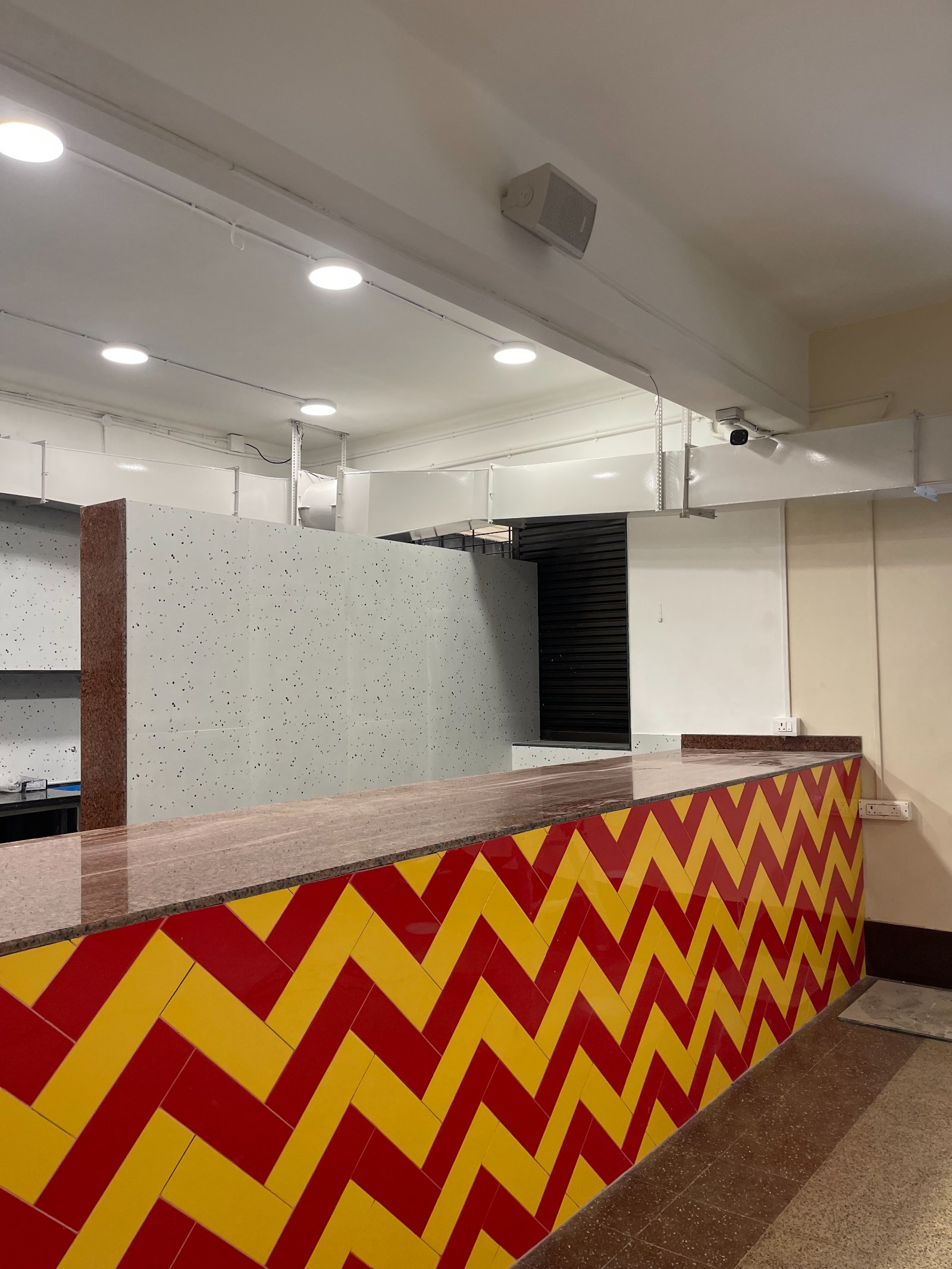 Nature-inspired preschool entrance with sculptural tree partitions and suspended green leaf ceiling panels.