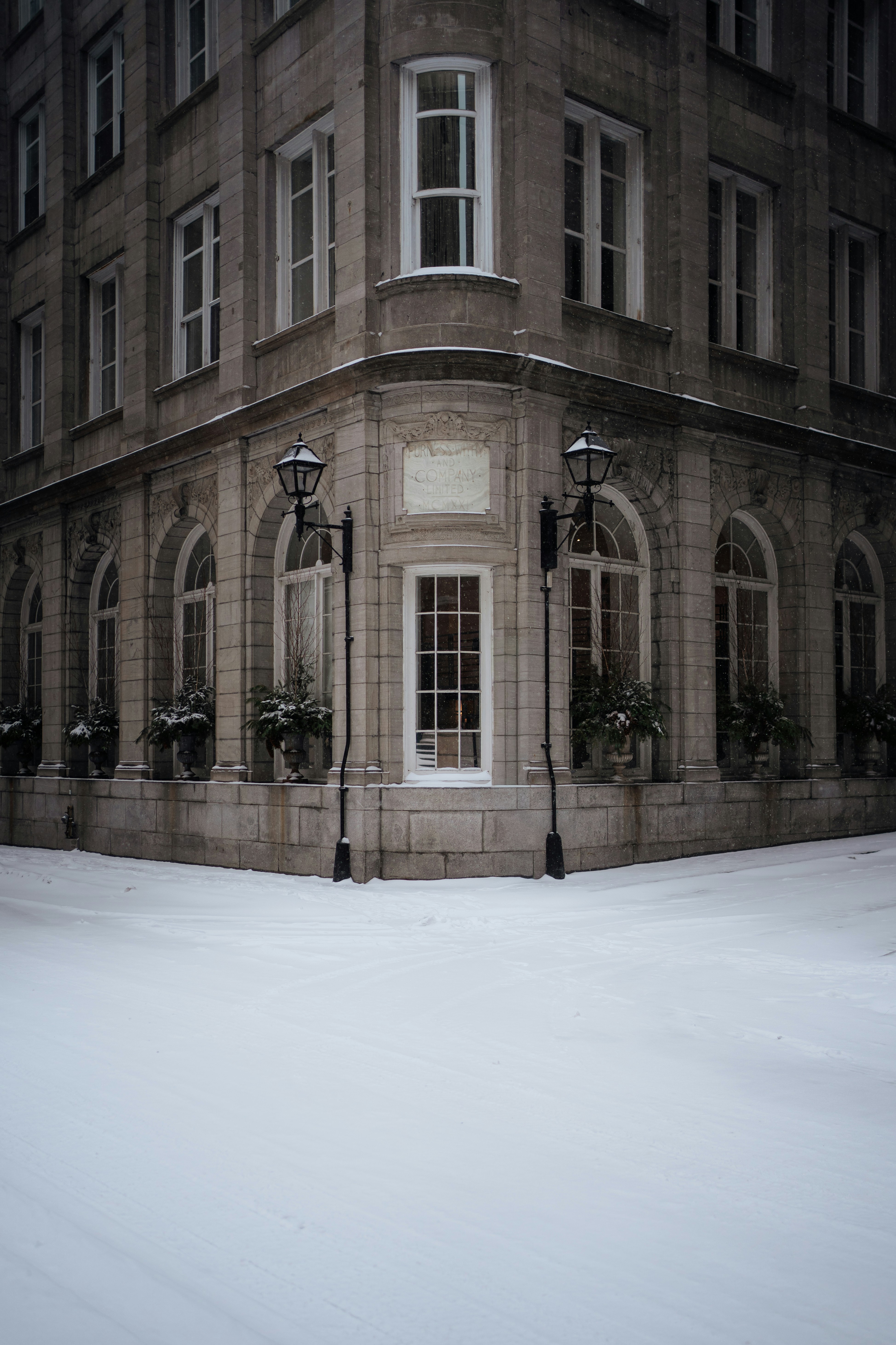 Elegant building corner with snow falling