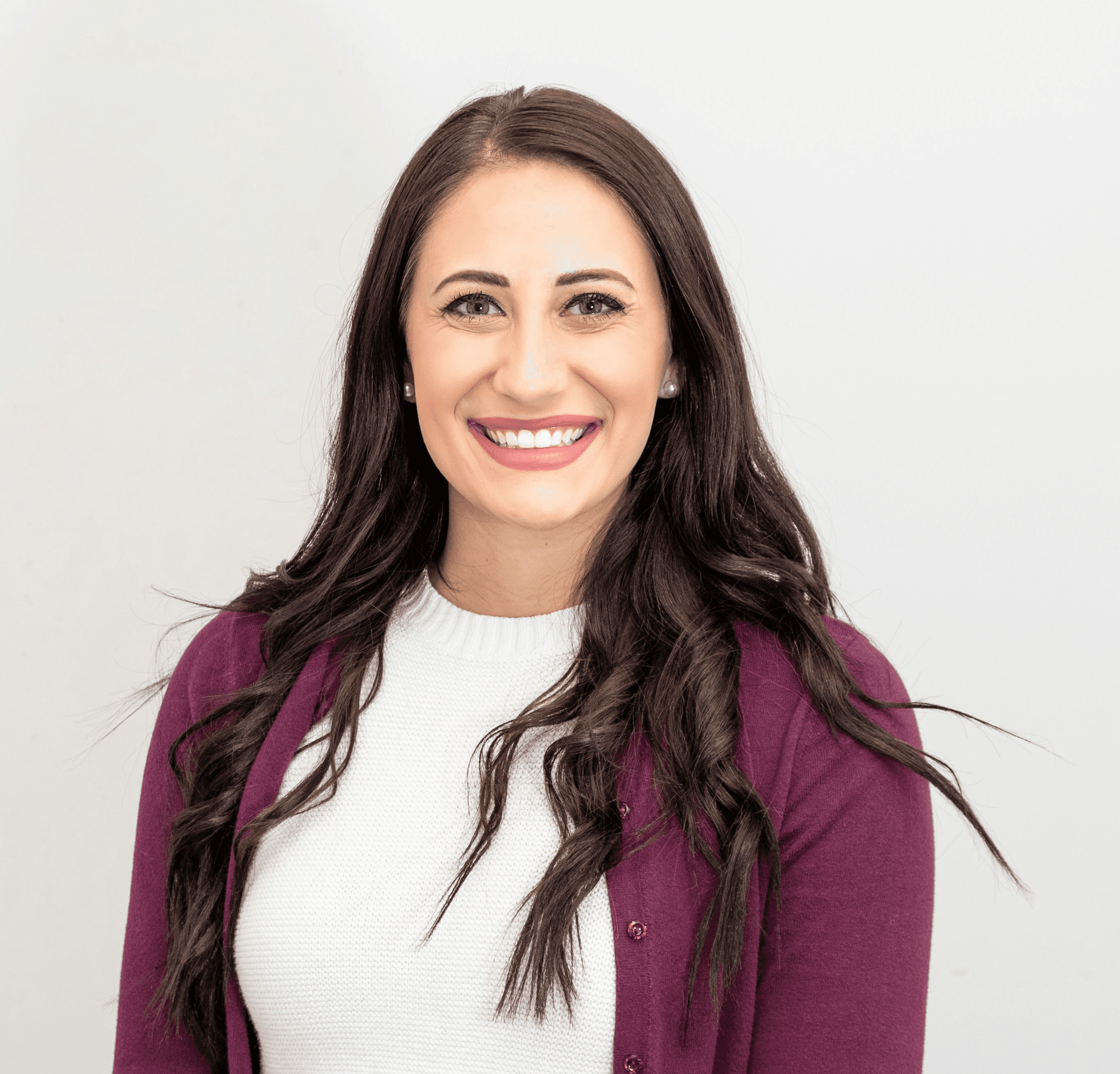 A woman in a chic red cardigan, radiating happiness with her smile.