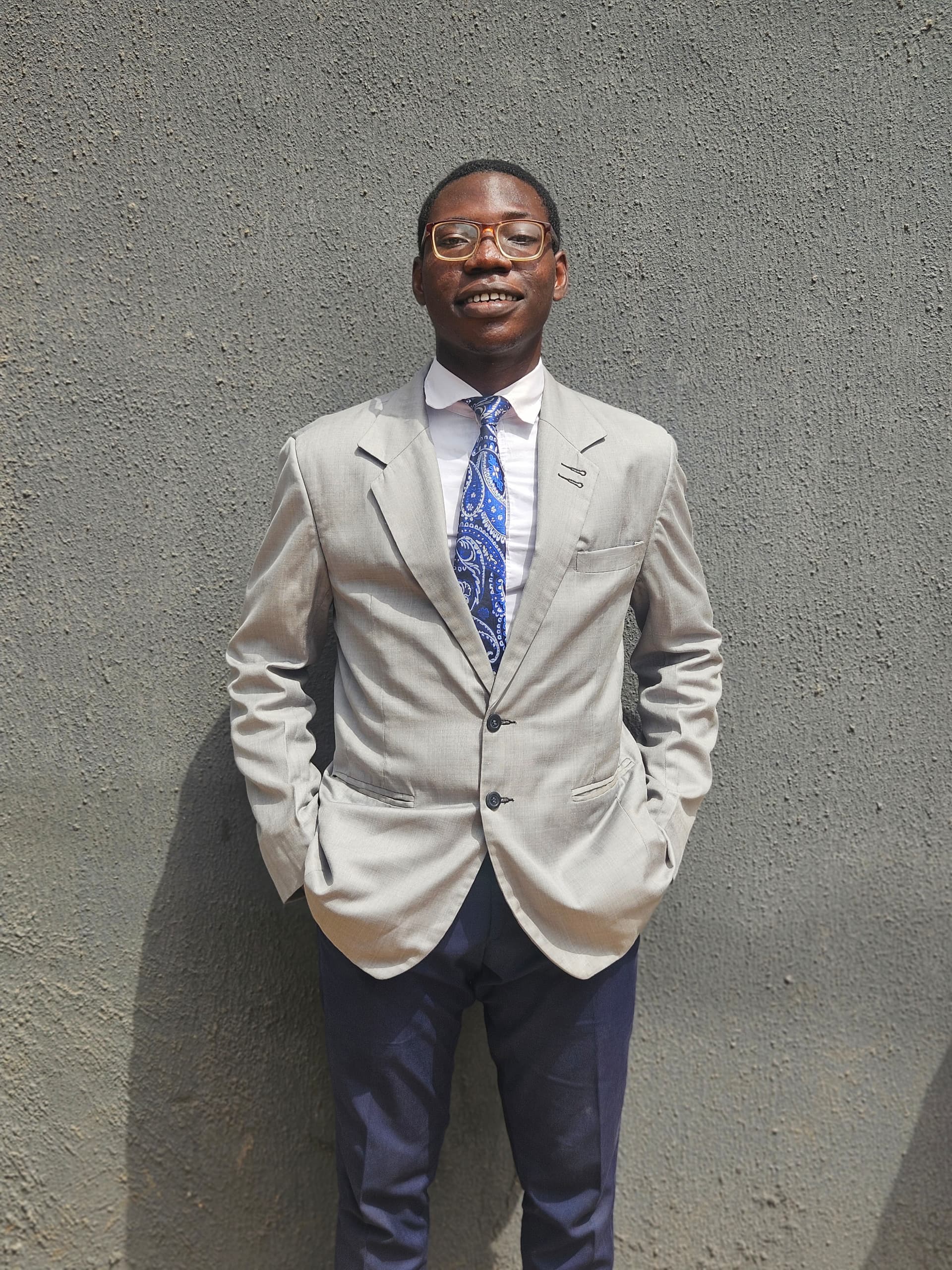 Victor Oluwole, wearing lasses, looking straight ahead.
