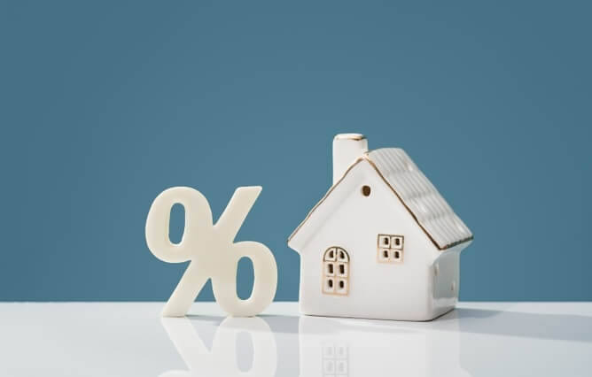 Percentage sign and house figurine