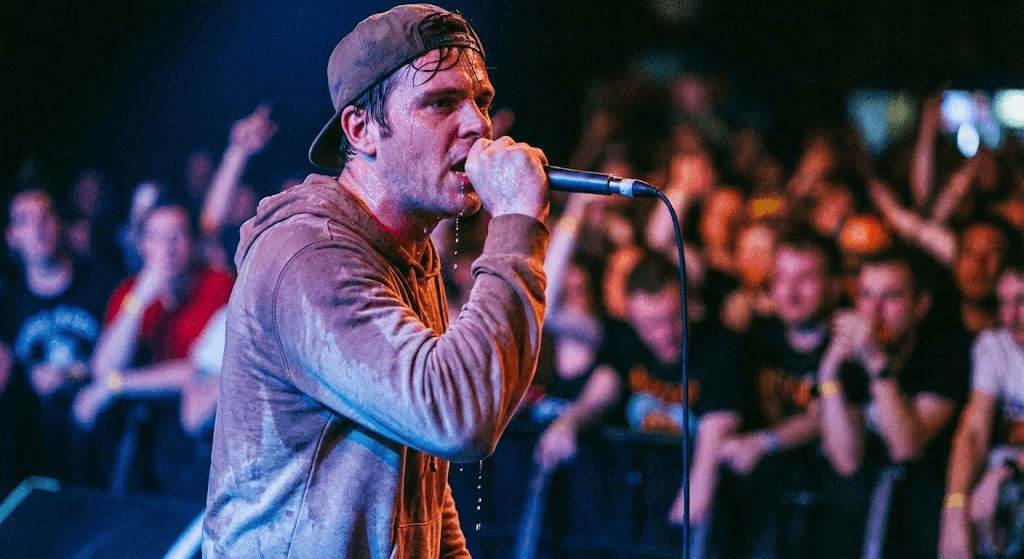 man in gray quarter-sleeved shirt singing