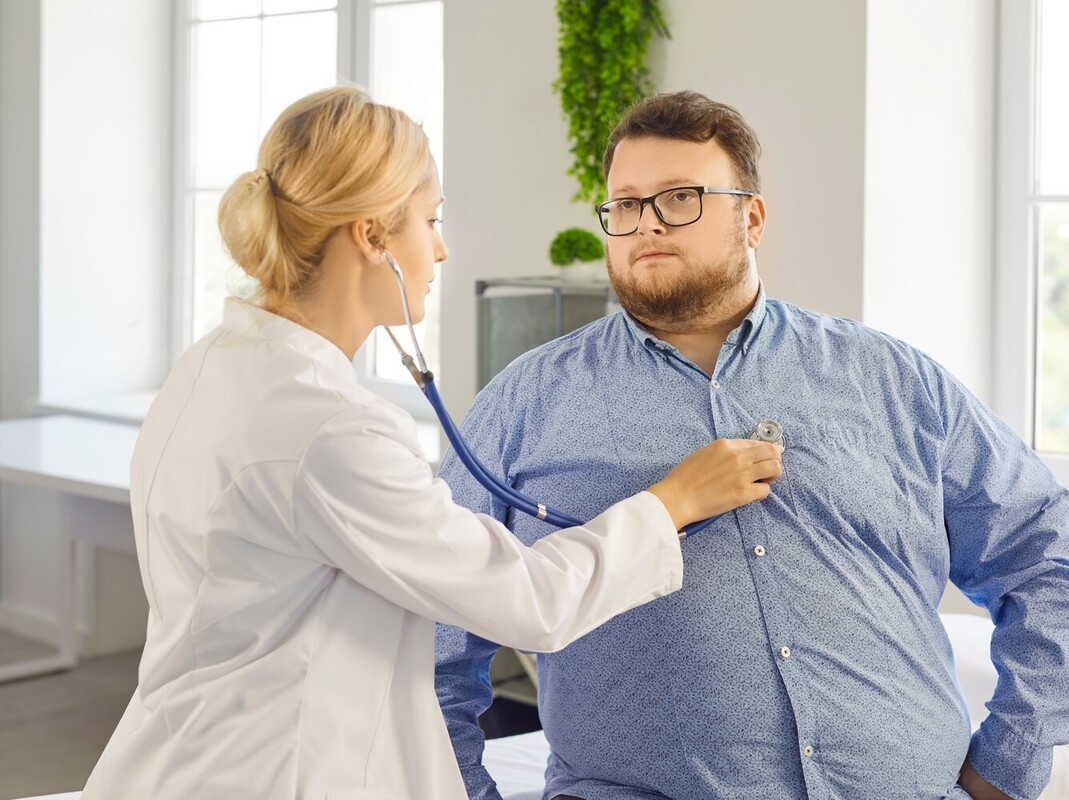 woman checking a patient out before prescribing him weight loss pills