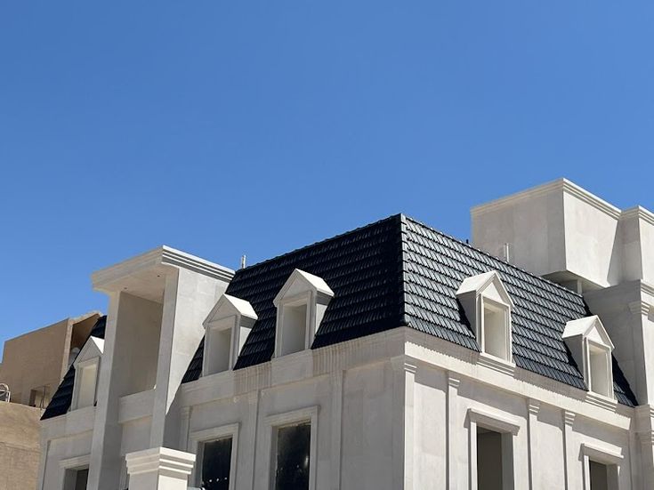 Woman with tablet on solar panel-covered rooftop under clear sky.