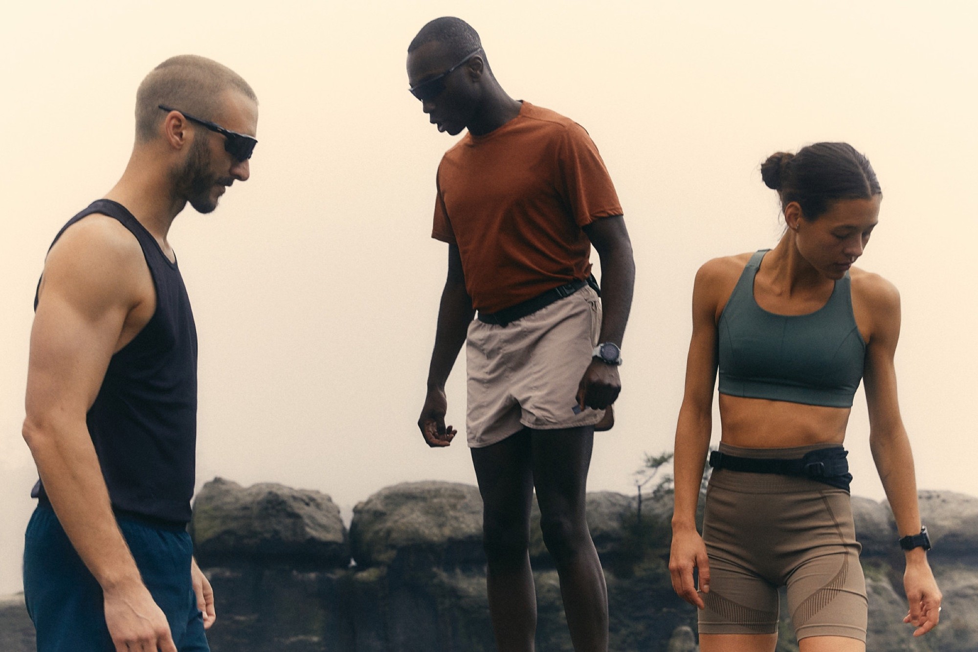 Three people standing on rocks in flat morning mist