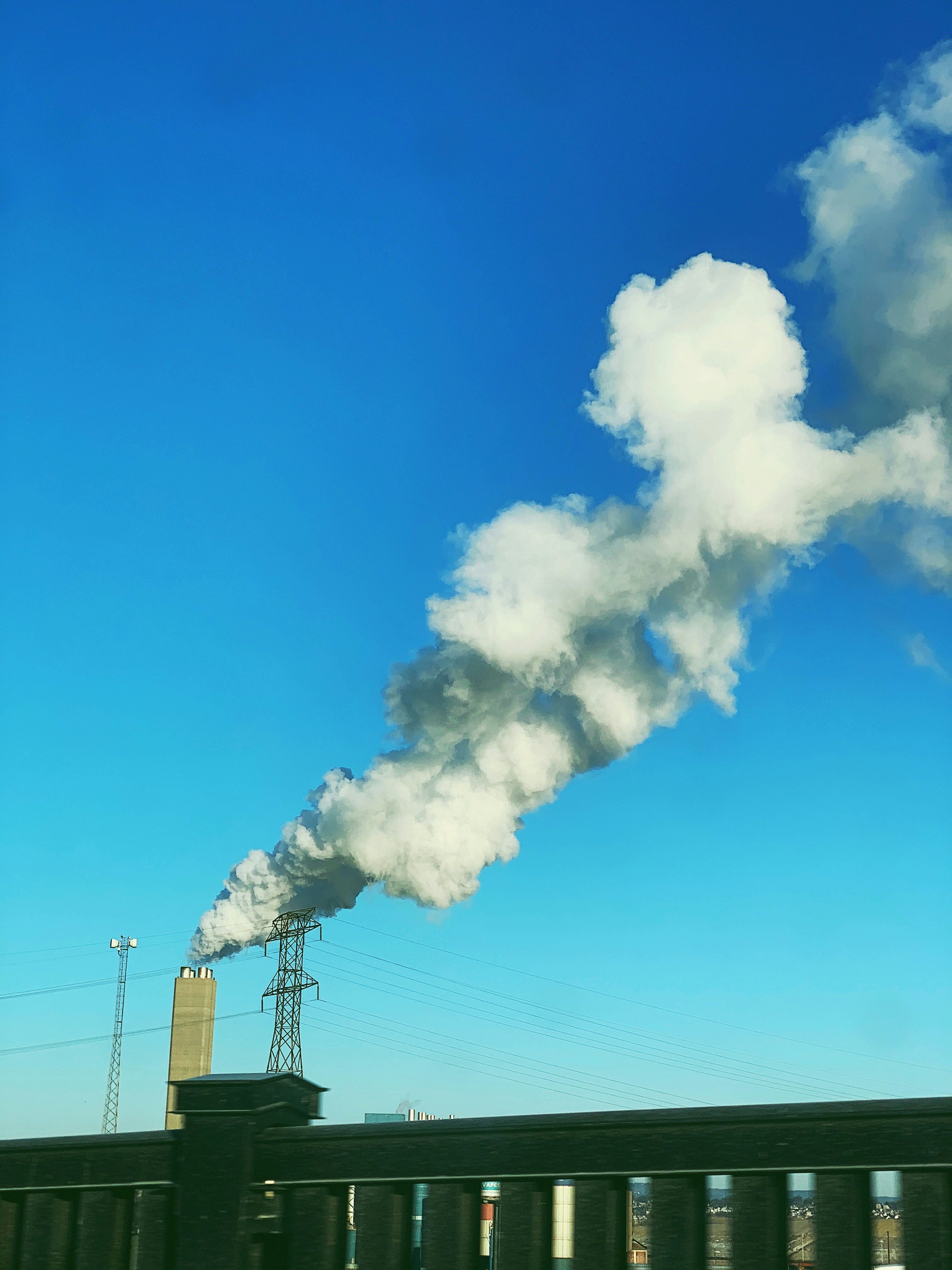 gray building with smoke under blue sky