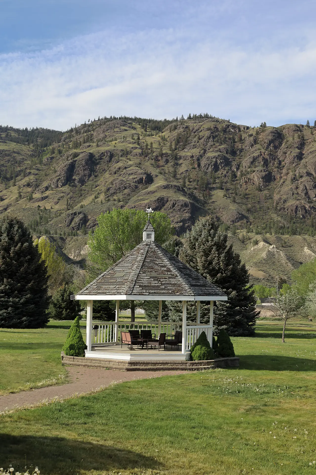 Gazebo in a park with a mountain range in the background.