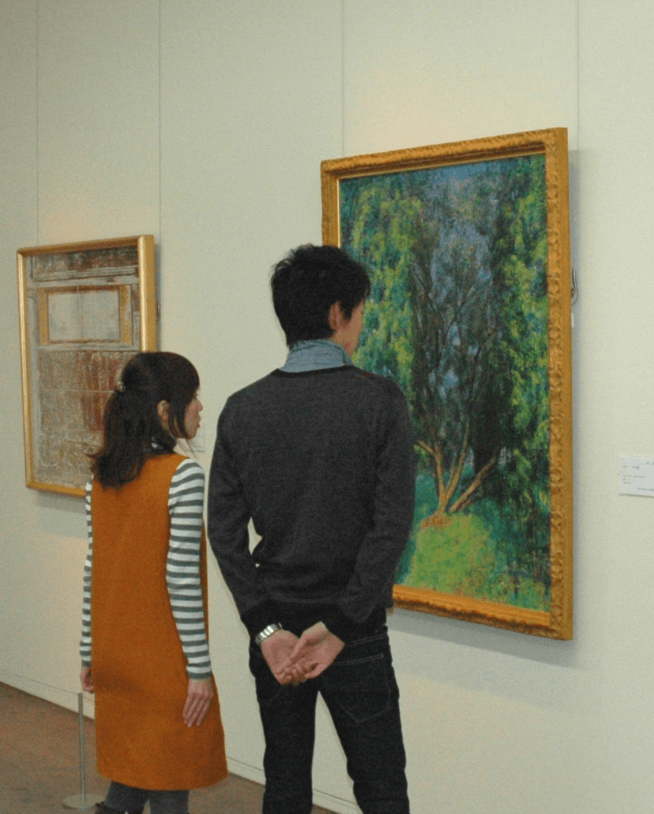 Two visitors looking at a painting of the olive groove