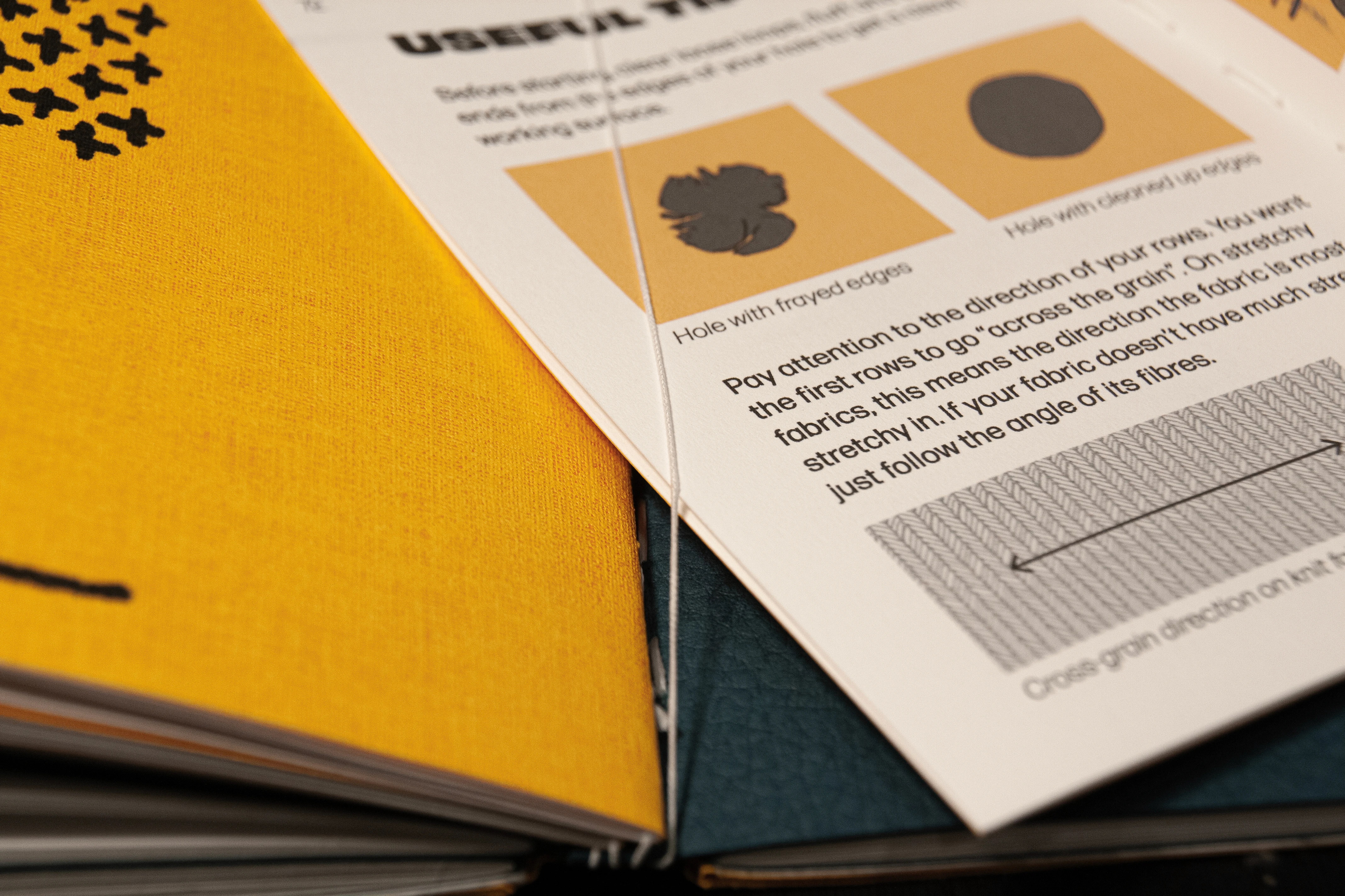 Close-up showing a booklet being slid under thing elastic within the guide book