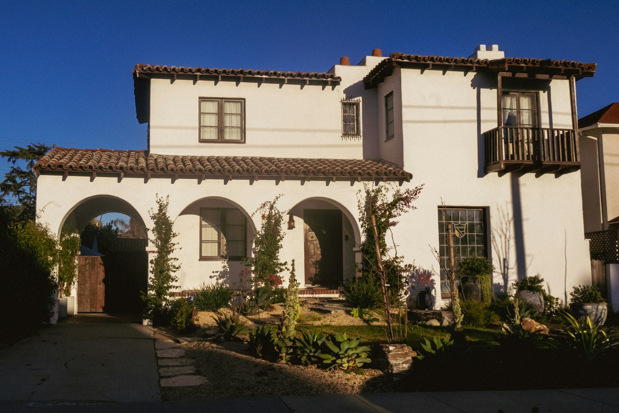 Spanish Colonial home with white stucco walls, terracotta roof and an arched front loggia