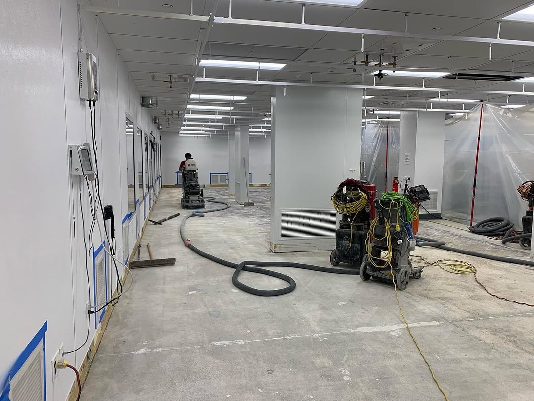 Crew grinding a slab inside a sealed containment area