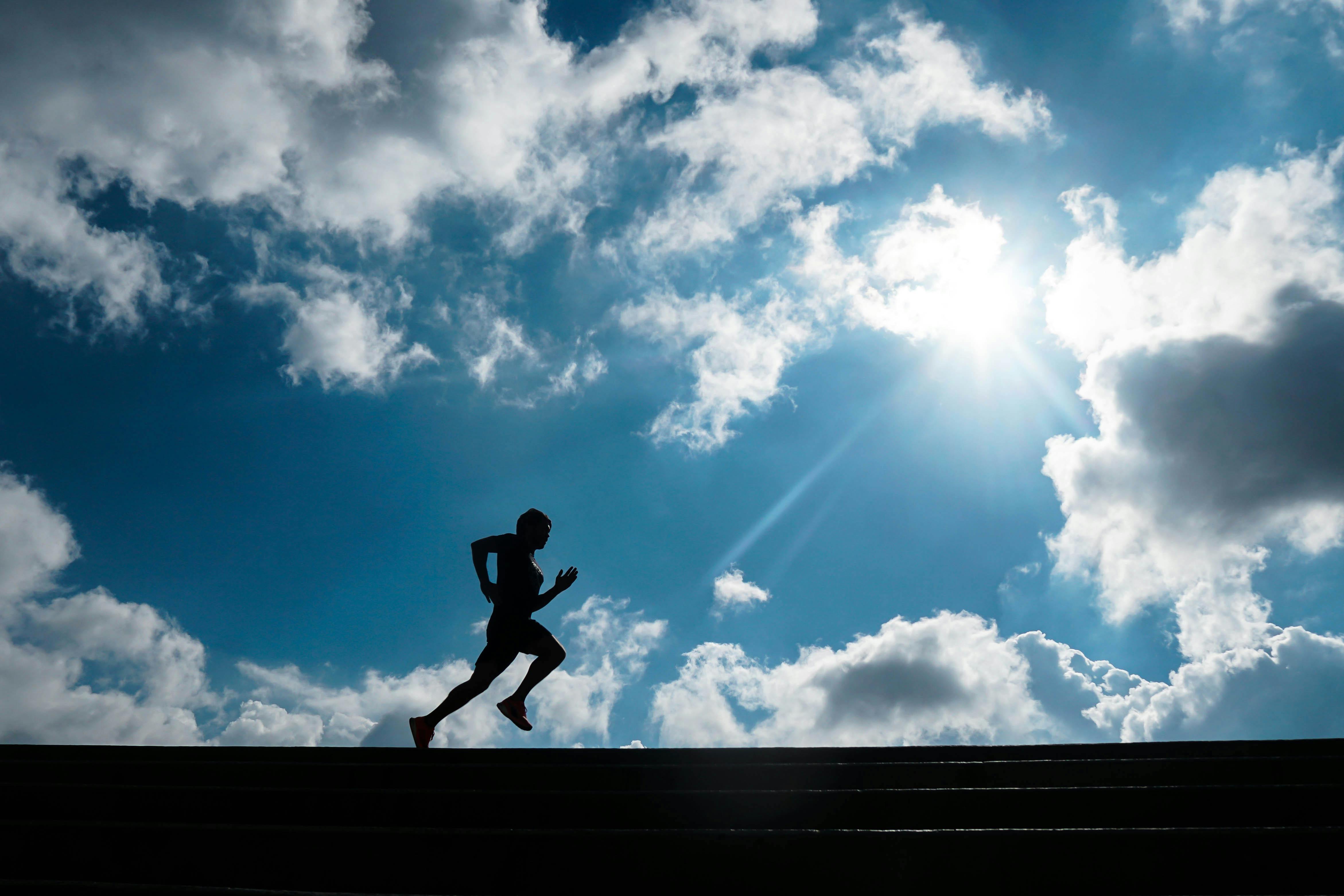 Runner's legs in motion on grassy terrain