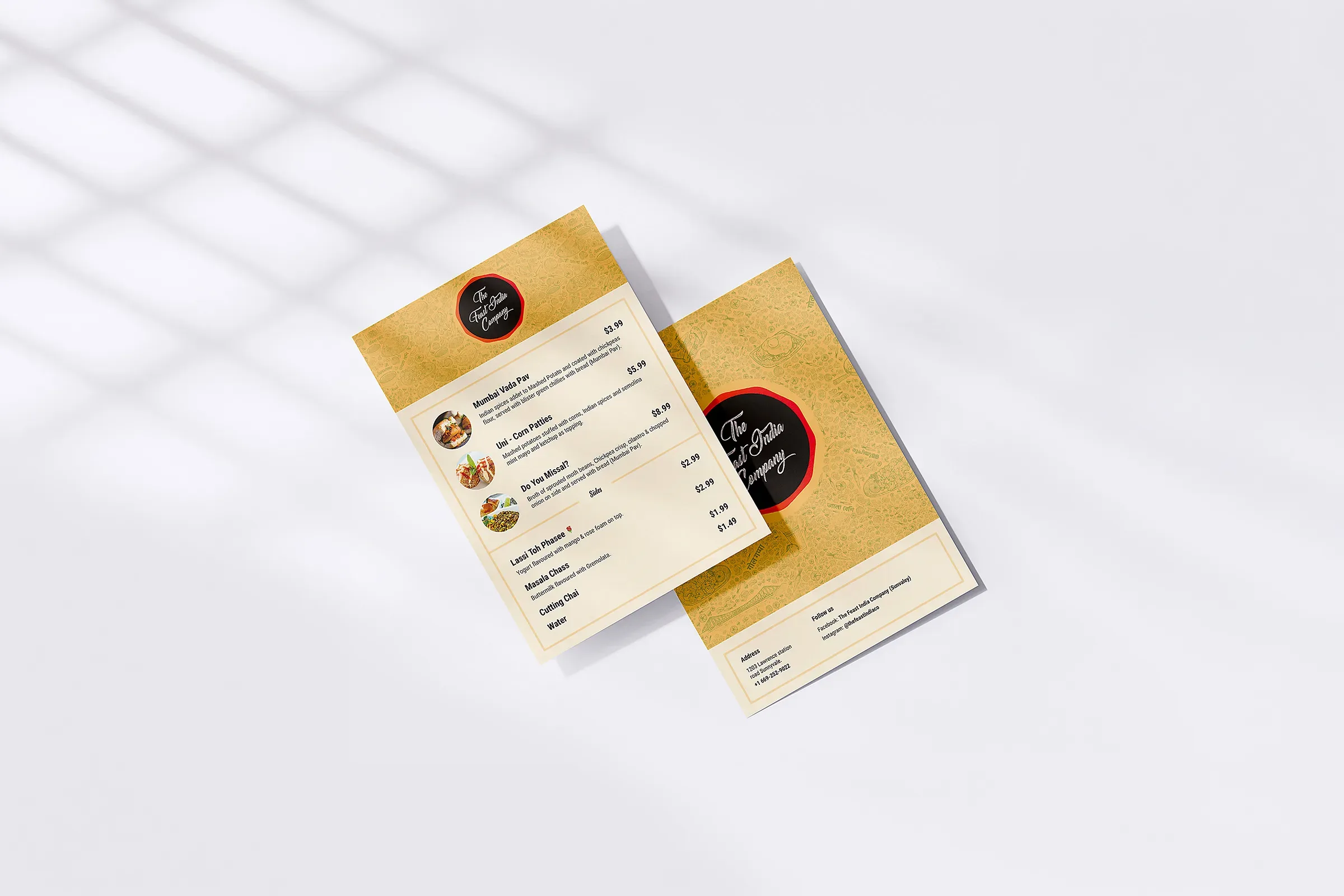 Beige restaurant menu cards with food listings and prices, arranged on a white surface with soft window shadows, creating a warm, elegant mood.