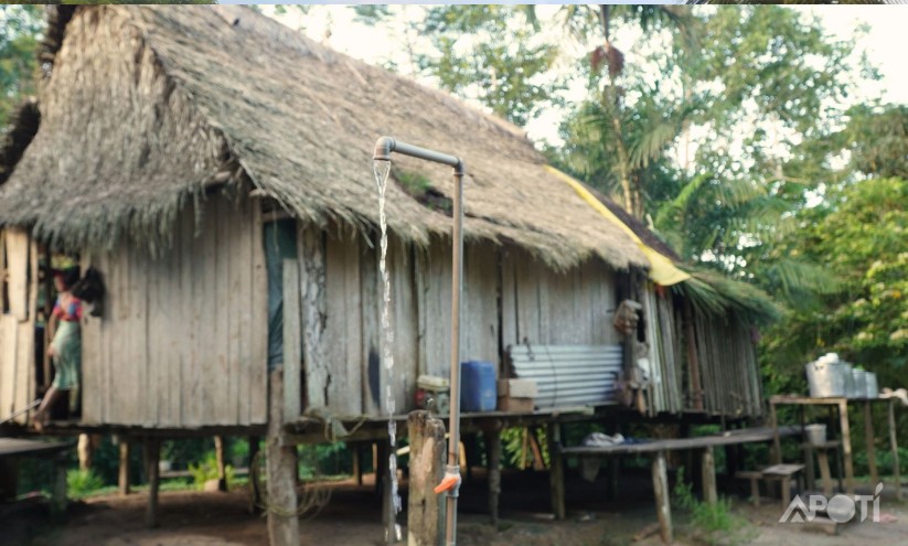 Casa na aldeia Huni Kuin com um cano dagua caindo agua