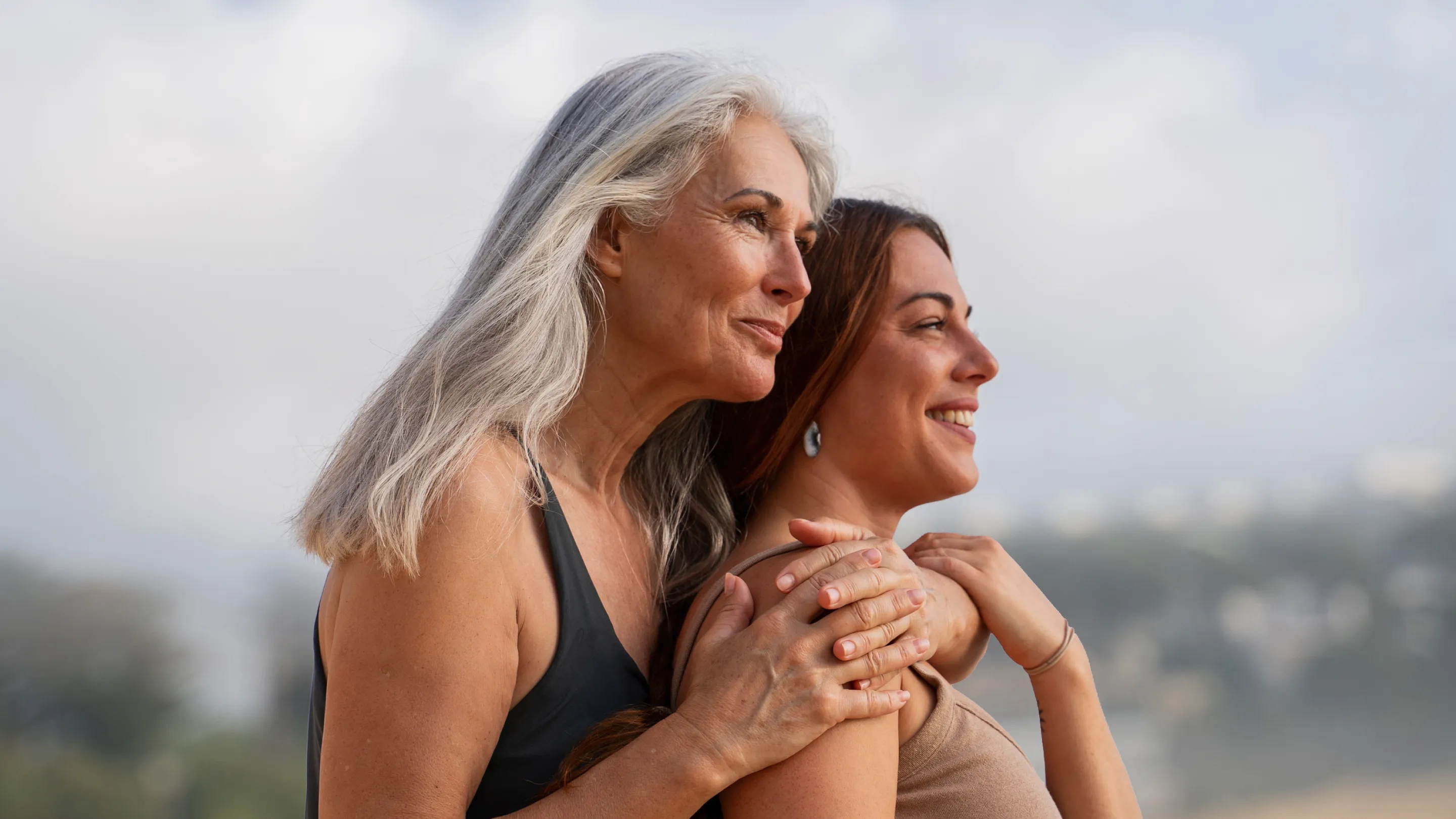 Woman embracing overlooking the ocean, representing preventive medicine for women and long-term health.