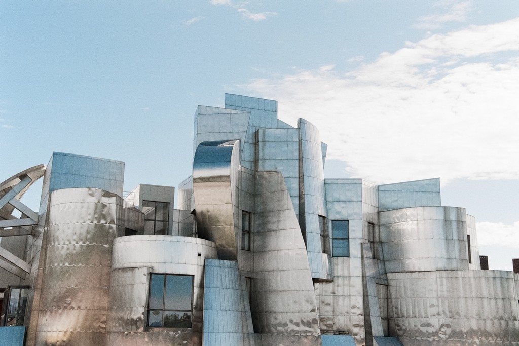 Shiny metallic structures with a partly cloud sky in the background