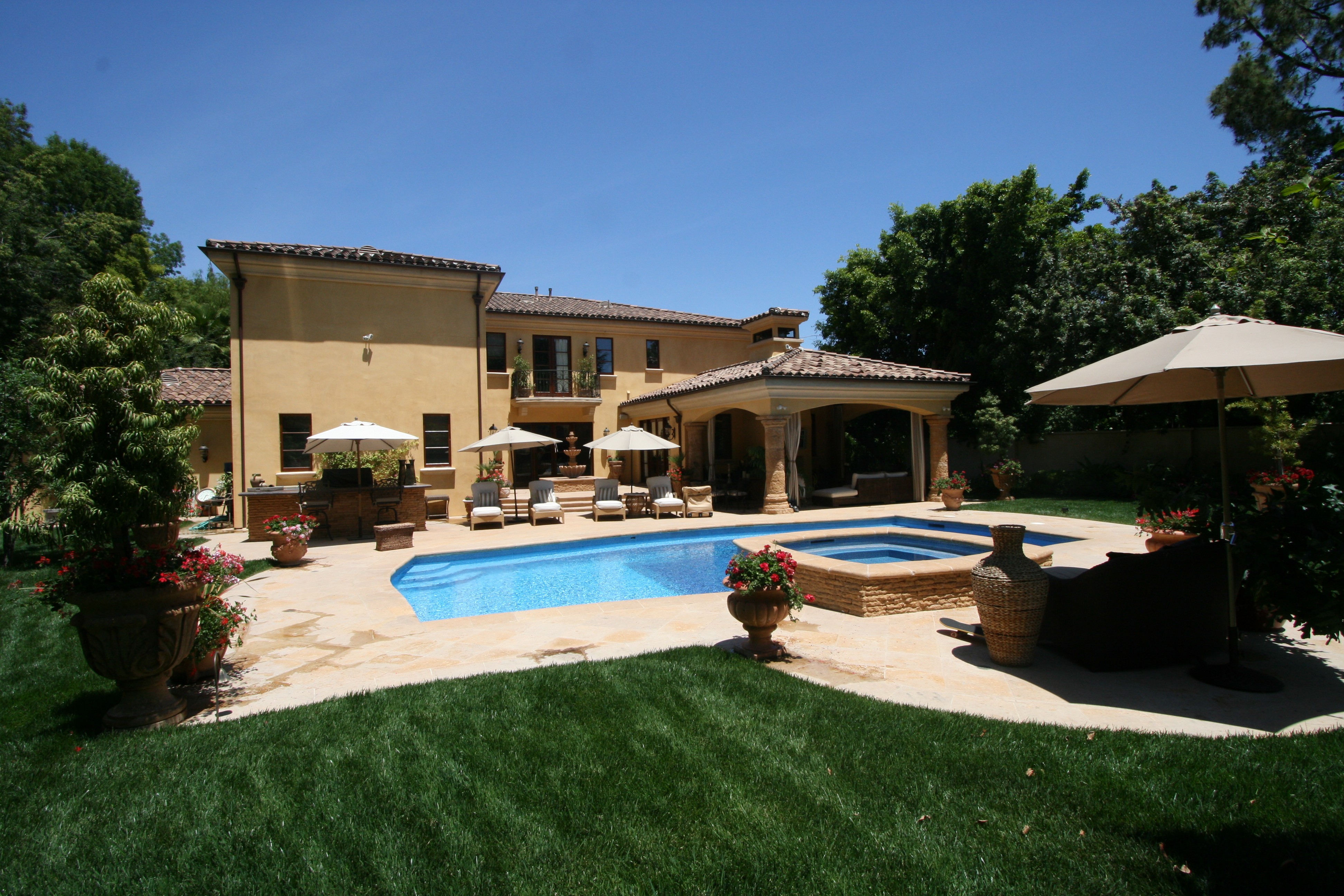 Backyard pool with green grass surrounding it, creating a serene outdoor space.