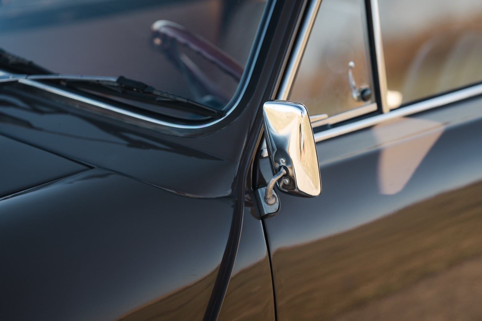 Close-up of a door latch with a metallic handle on a blue car door.