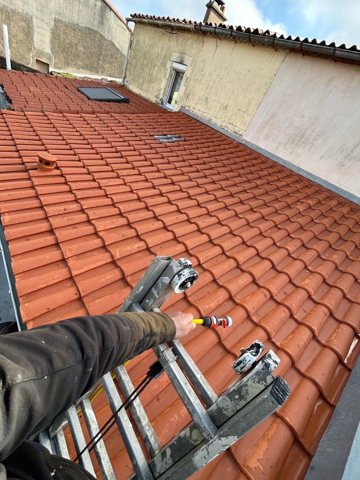 Couvreur inspectant une toiture en ardoise dans le quartier Doulon-Bottière à Nantes