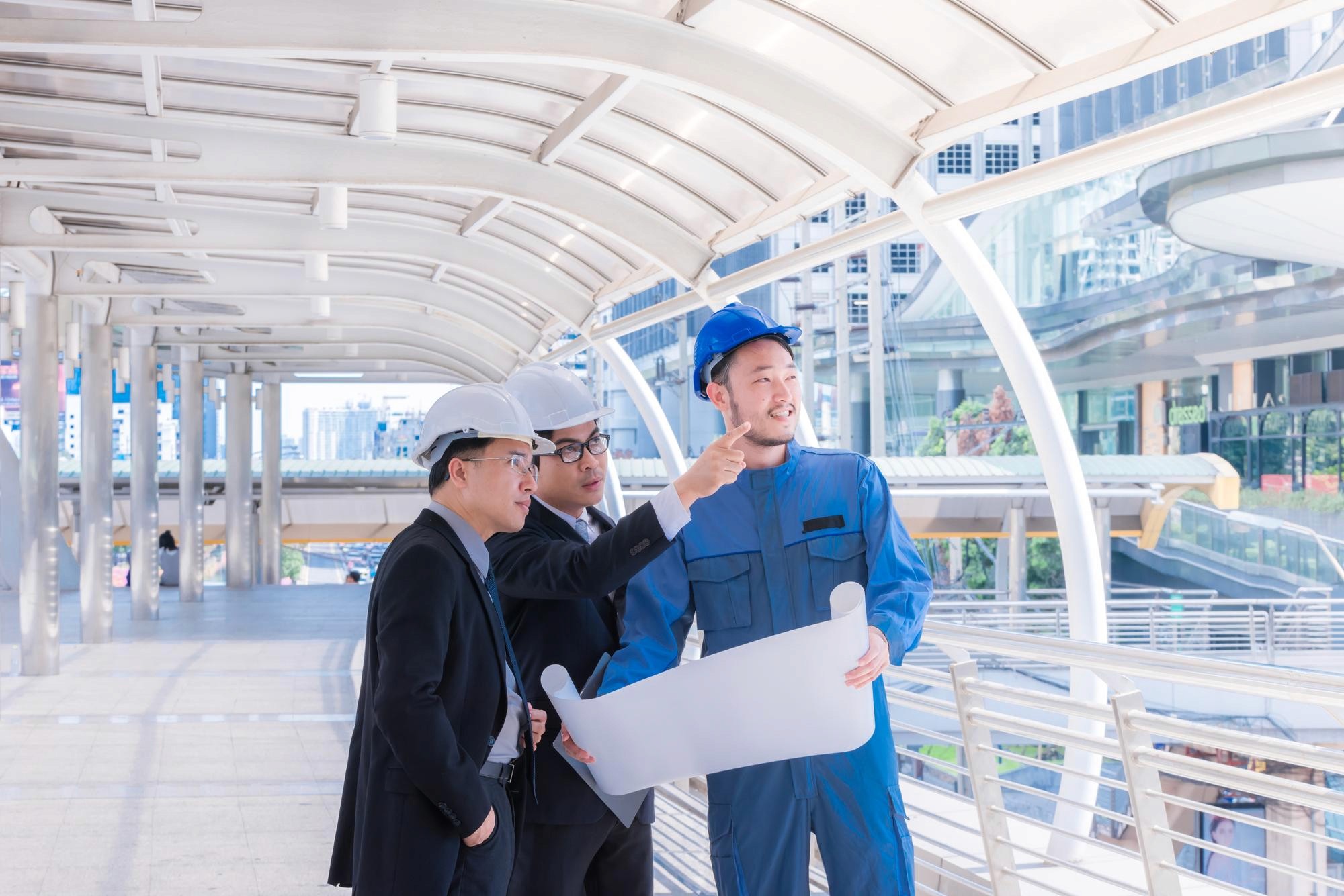 室內設計團隊討論機場店舖裝修方案,工作台展示工程物料樣本及建築模型