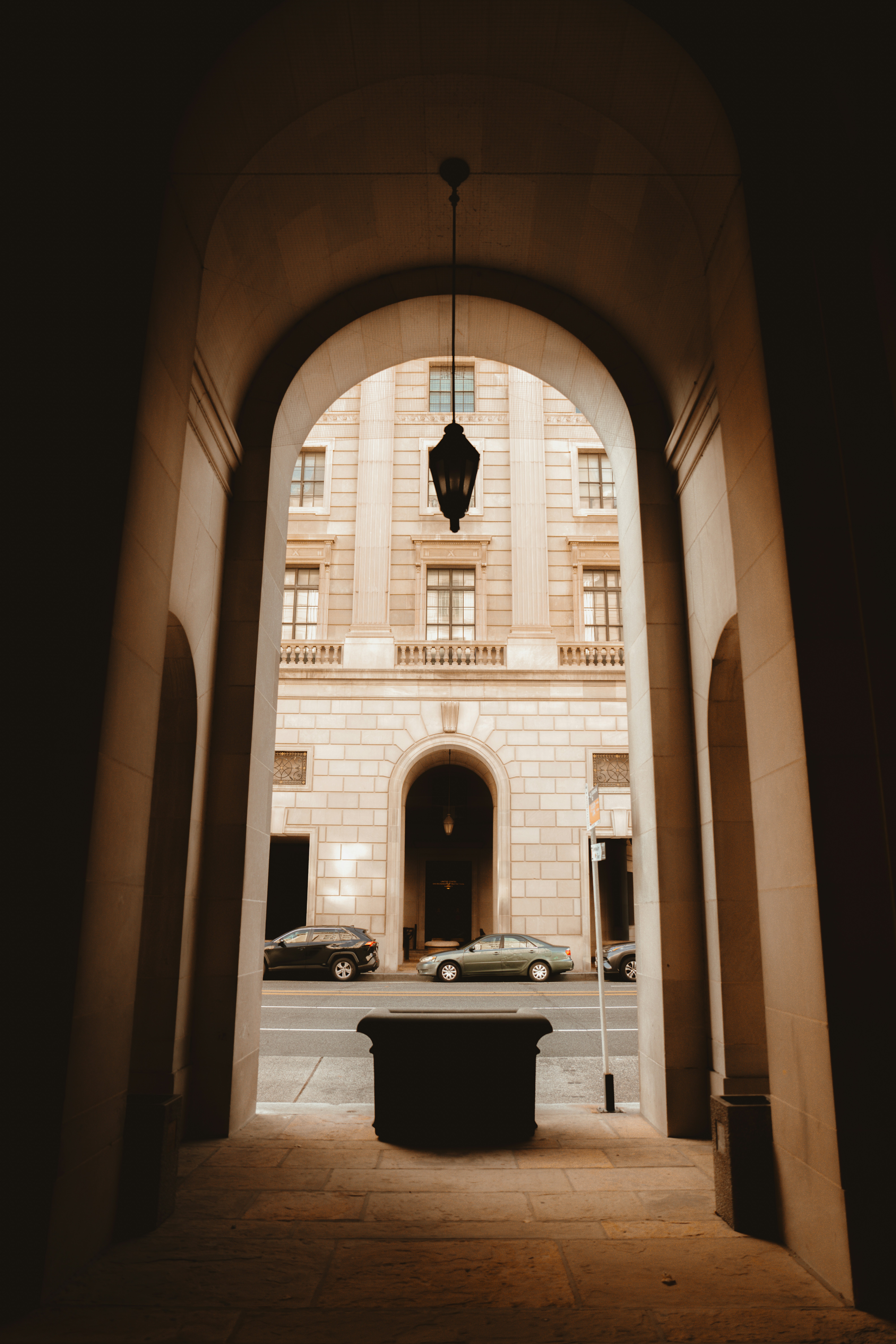 Arched entryway with cars and building facade
