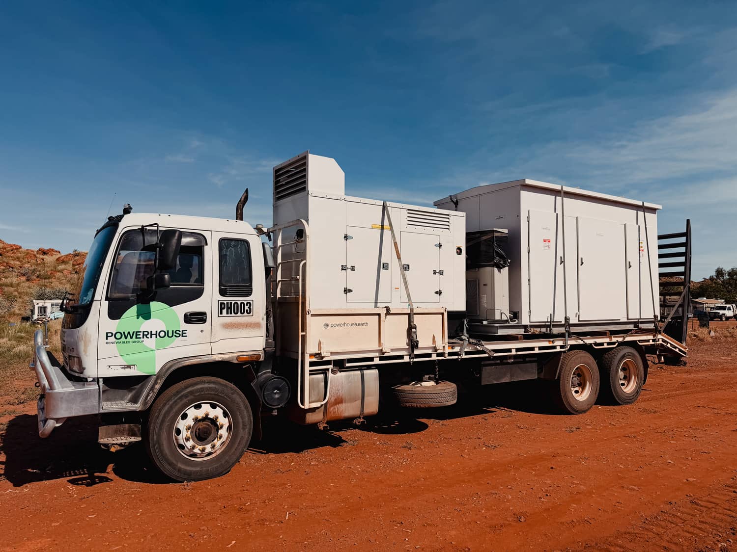 Powerhouse Renewables Group truck carrying mobile generator and energy storage system in remote Australian landscape.