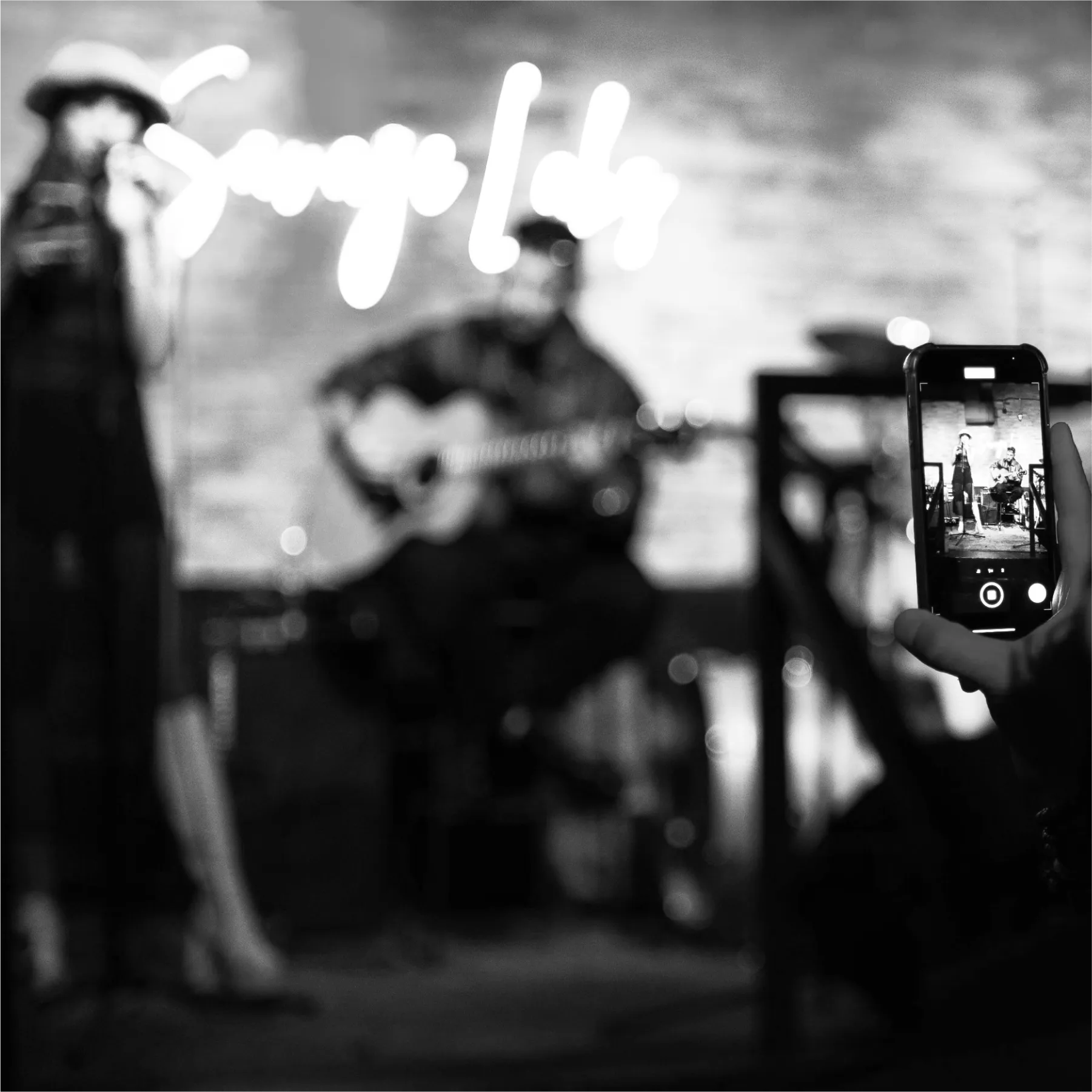 A fan recording a video of their favourite music band playing.