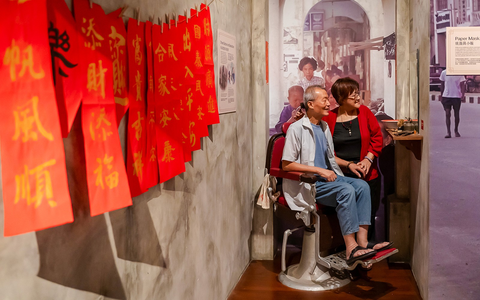 Visitors exploring the Arrival and Settling In exhibit at Chinatown Heritage Centre, Singapore.