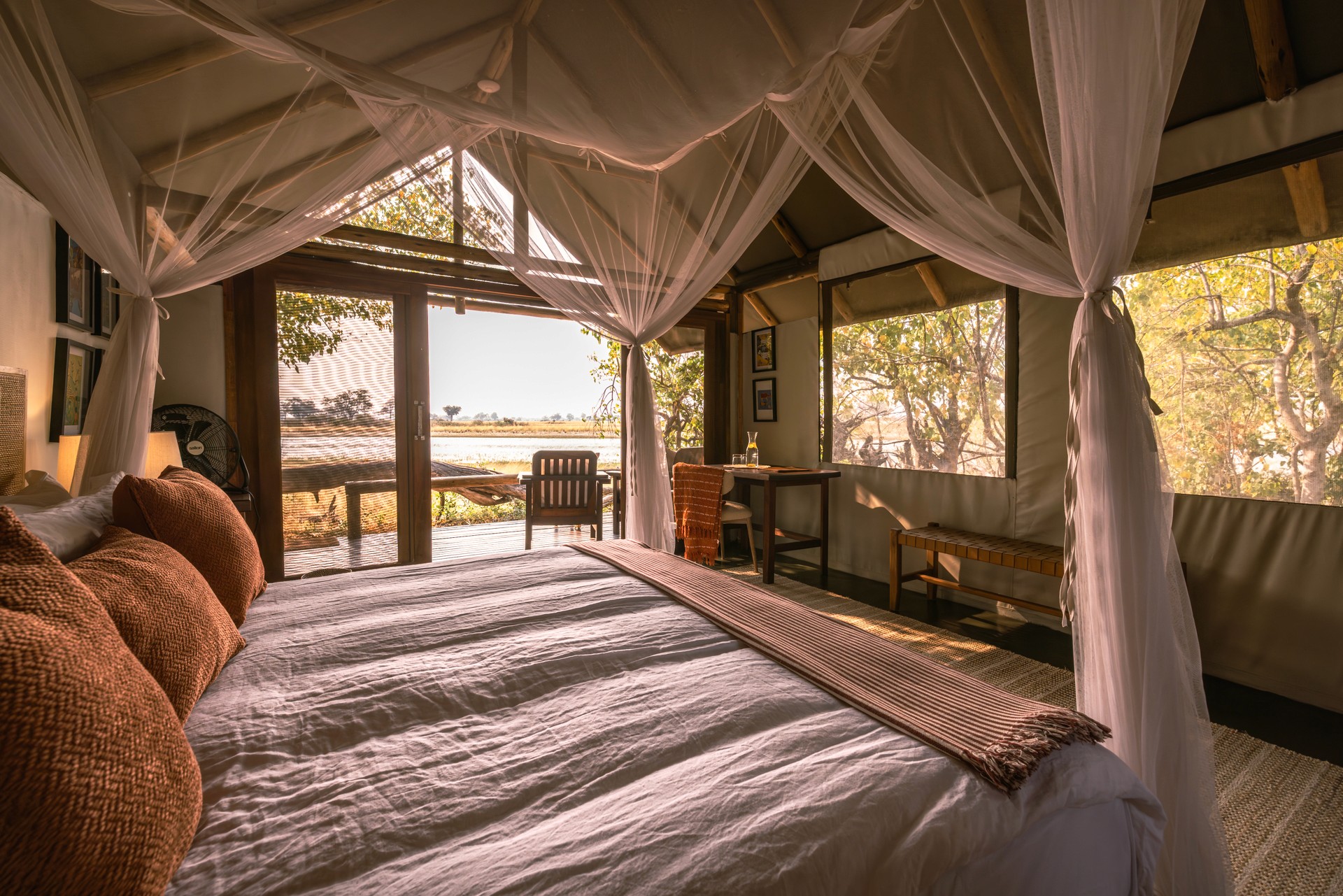 Kujwana Delta Ride, Okavango Delta, Botswana. Lyxigt och rymligt boende på Kujwana Camp. Vackert bäddad dubbelsäng med myggnät runtomsig, mjuk matta på golvet, lampor som ger ett mysigt sken och öppna dörrar från rummet som har utsikt över Okavango Delta.