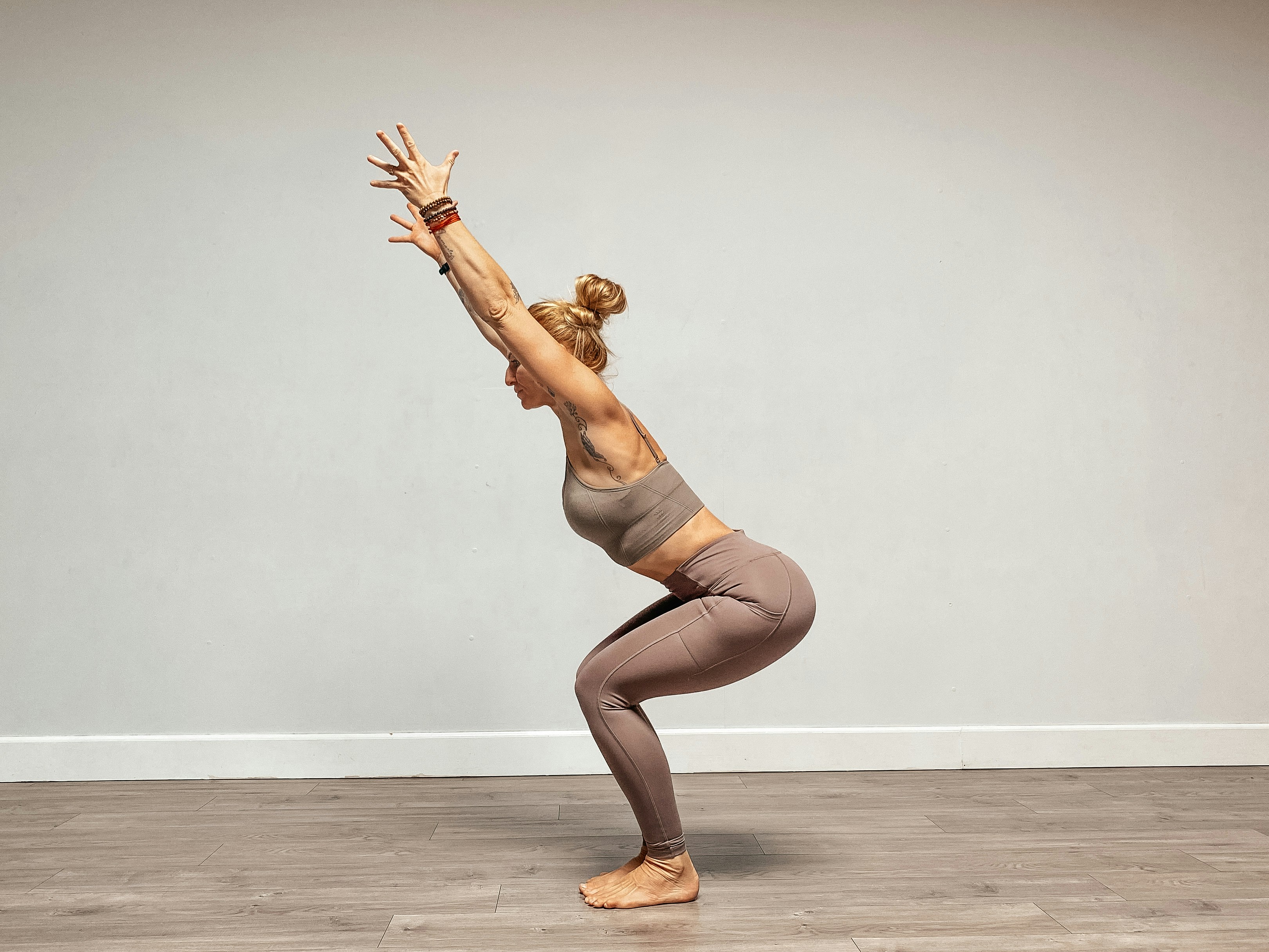 a woman doing a yoga pose on a wooden floor