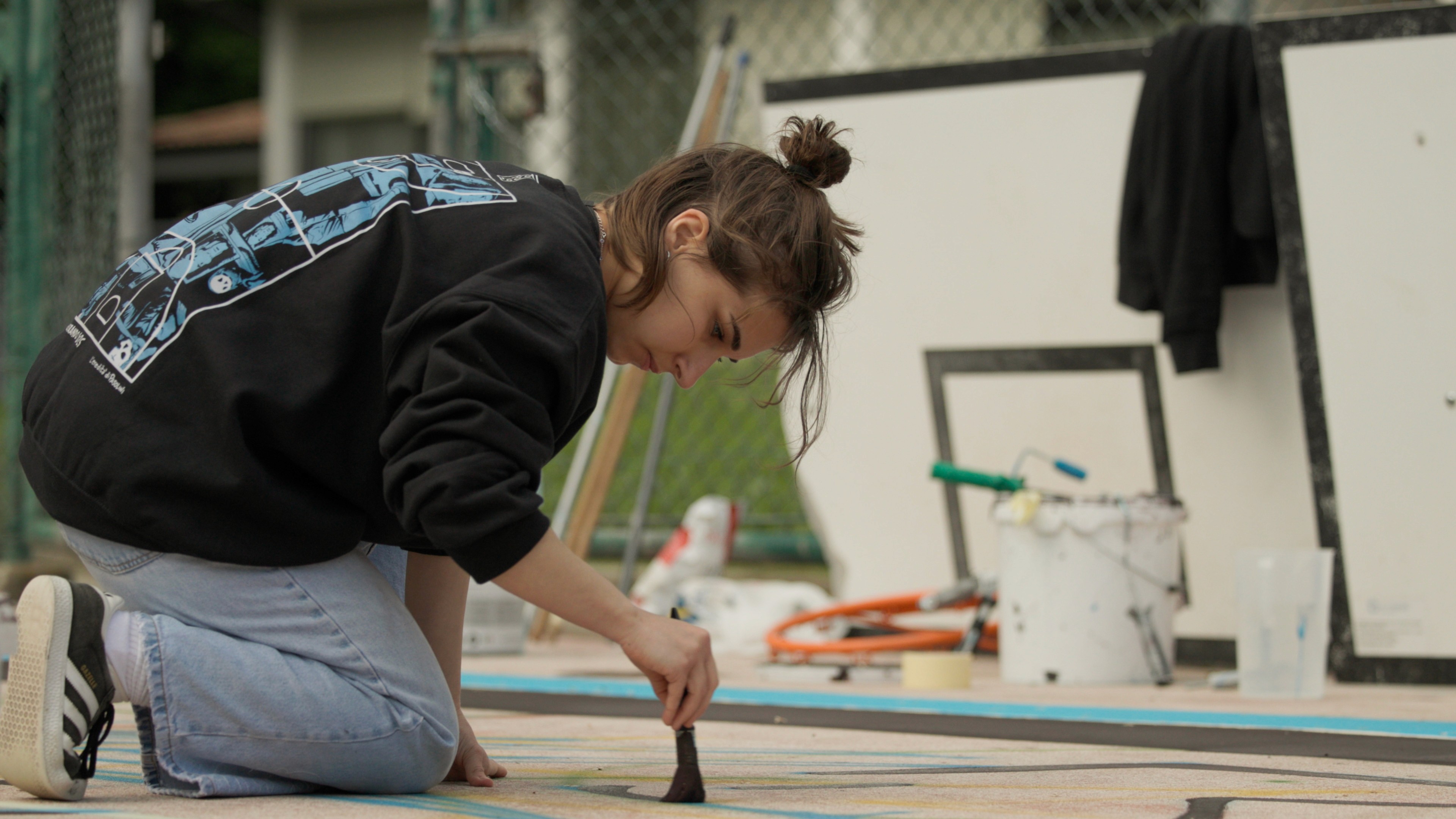 Modern red brick apartment or office building viewed from below against a blue sky, showcasing its geometric architecture with evenly spaced windows and balconies.