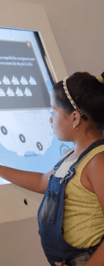 Portrait of a laughing person with curly hair wearing a white shirt