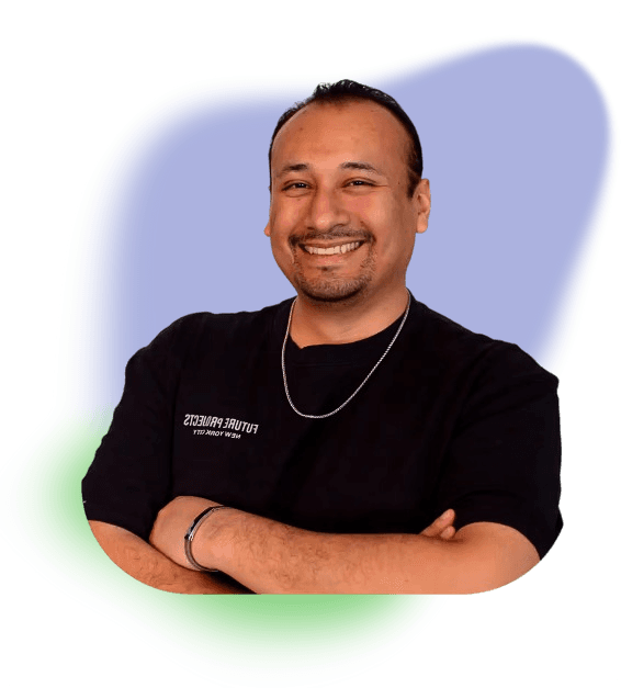 Renato Pinto con una camiseta negra, con los brazos cruzados y sonriendo a la cámara