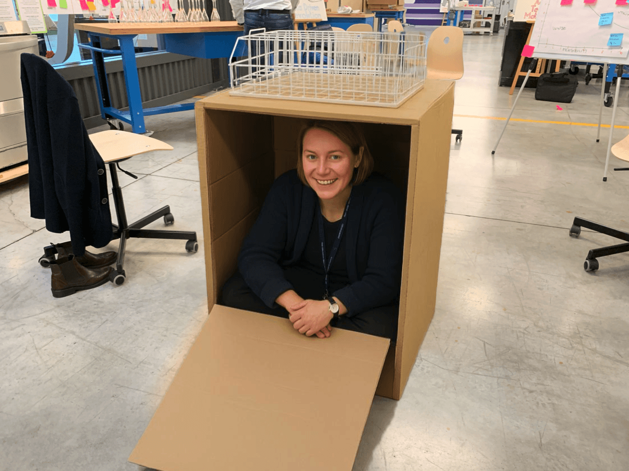 Partecipante che testa prototipo a grandezza reale all’interno di mockup di cartone