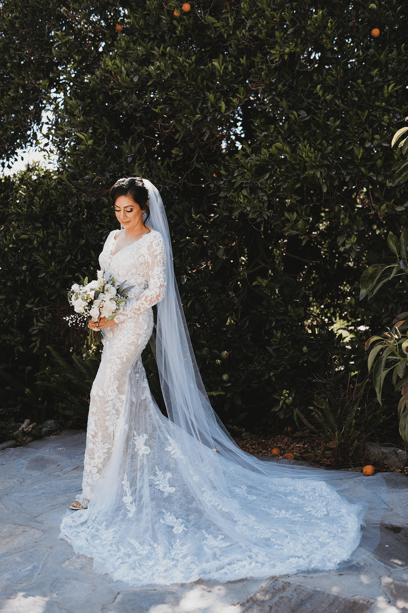 Bride portrait on patio with orange trees behind her