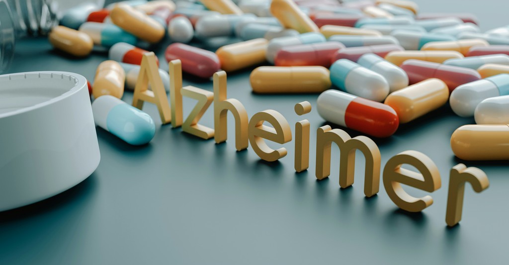 A variety of colorful capsules scattered on a surface with the word "Alzheimer" prominently displayed, representing medication and treatment efforts for Alzheimer's disease.