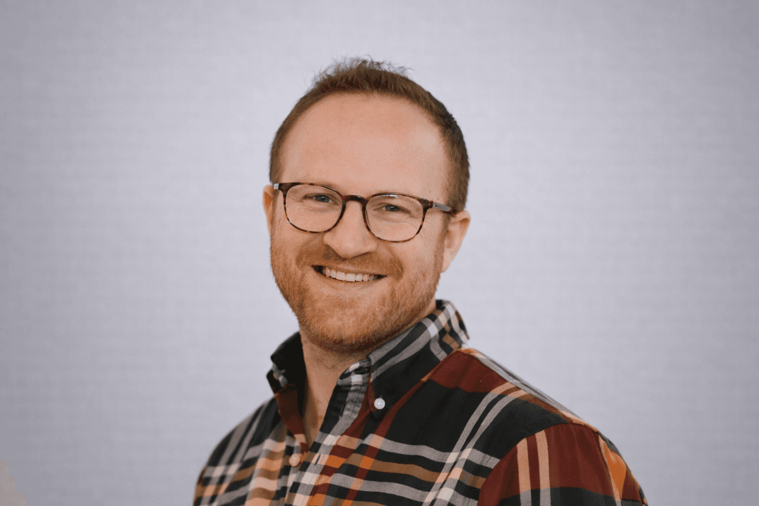 Black and white portrait of a smiling person with curly hair